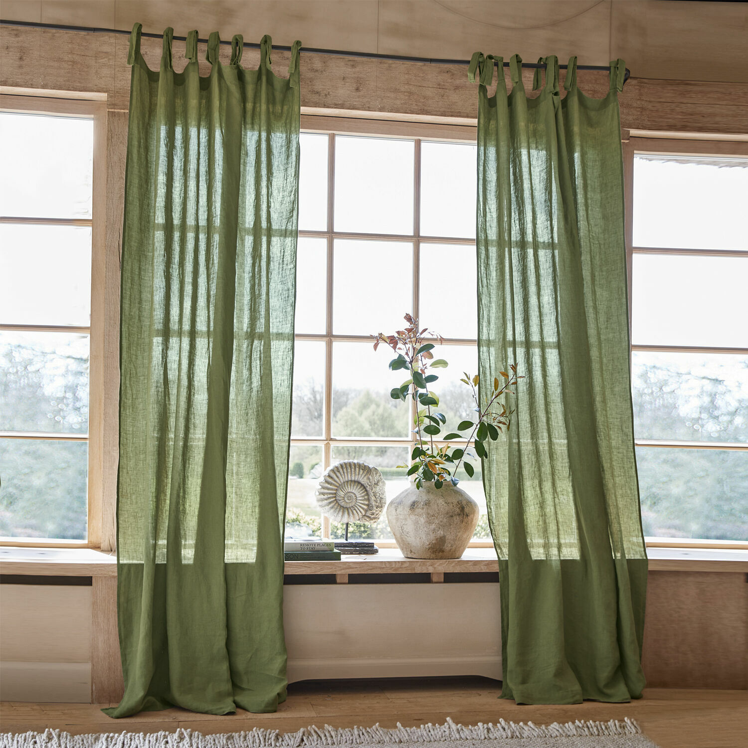 Rideau Adara Rideaux en lin vert avec boucles pour tringle dans un intérieur lumineux et naturel avec décoration de fenêtre