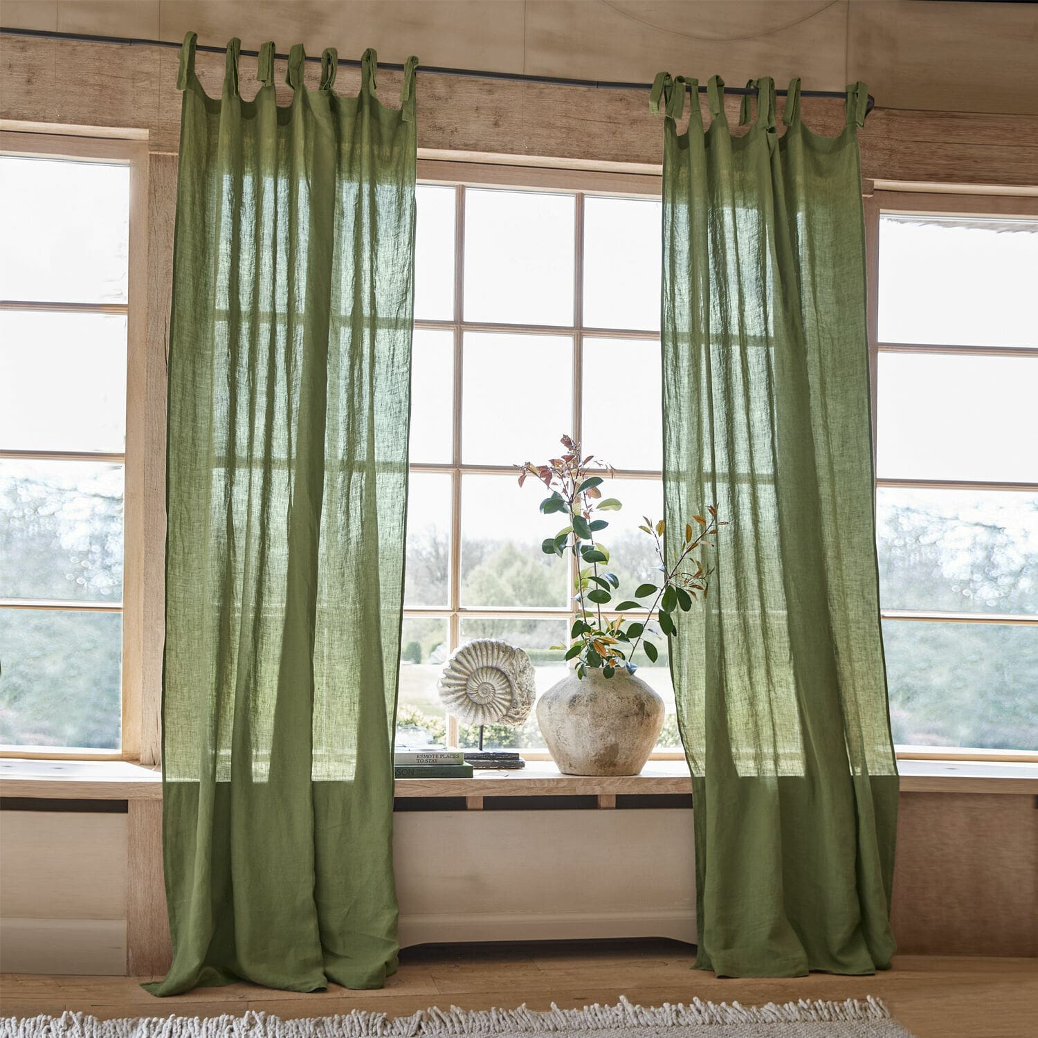 Rideau Adara Rideaux en lin vert avec boucles pour tringle dans un intérieur lumineux et naturel avec décoration de fenêtre