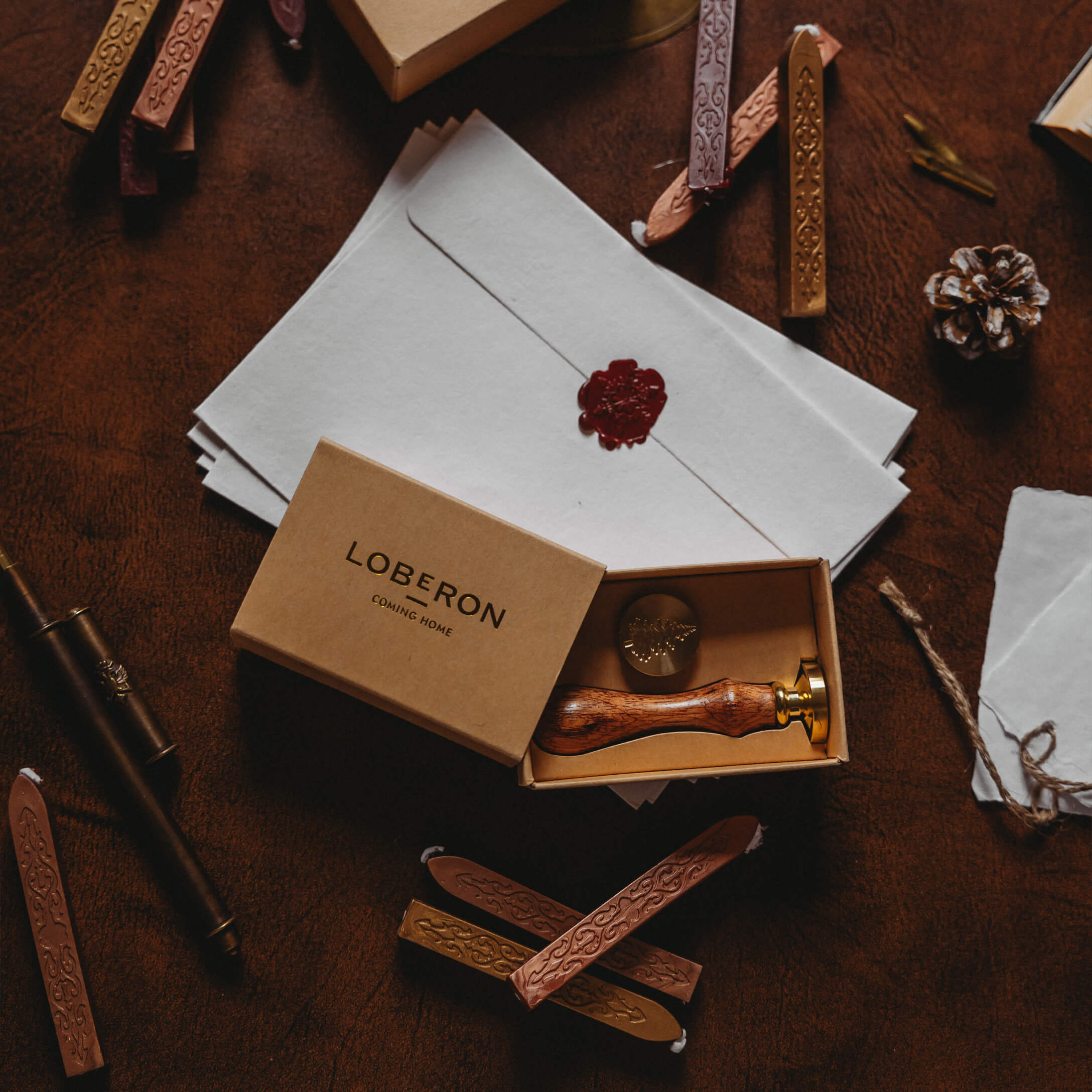 Ensemble de sceau avec poignée en bois et bâtons de cire sur fond marron avec enveloppes