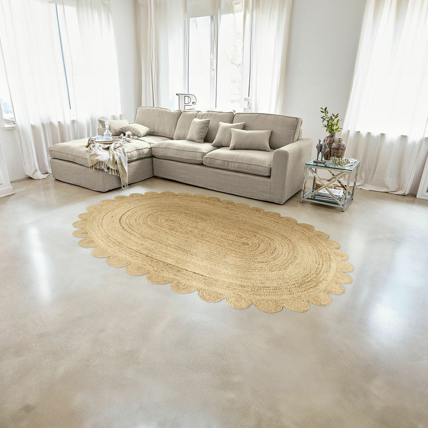 Tapis Ferce Tapis ovale en jute couleur naturelle avec bord festonné dans un salon clair avec canapé beige