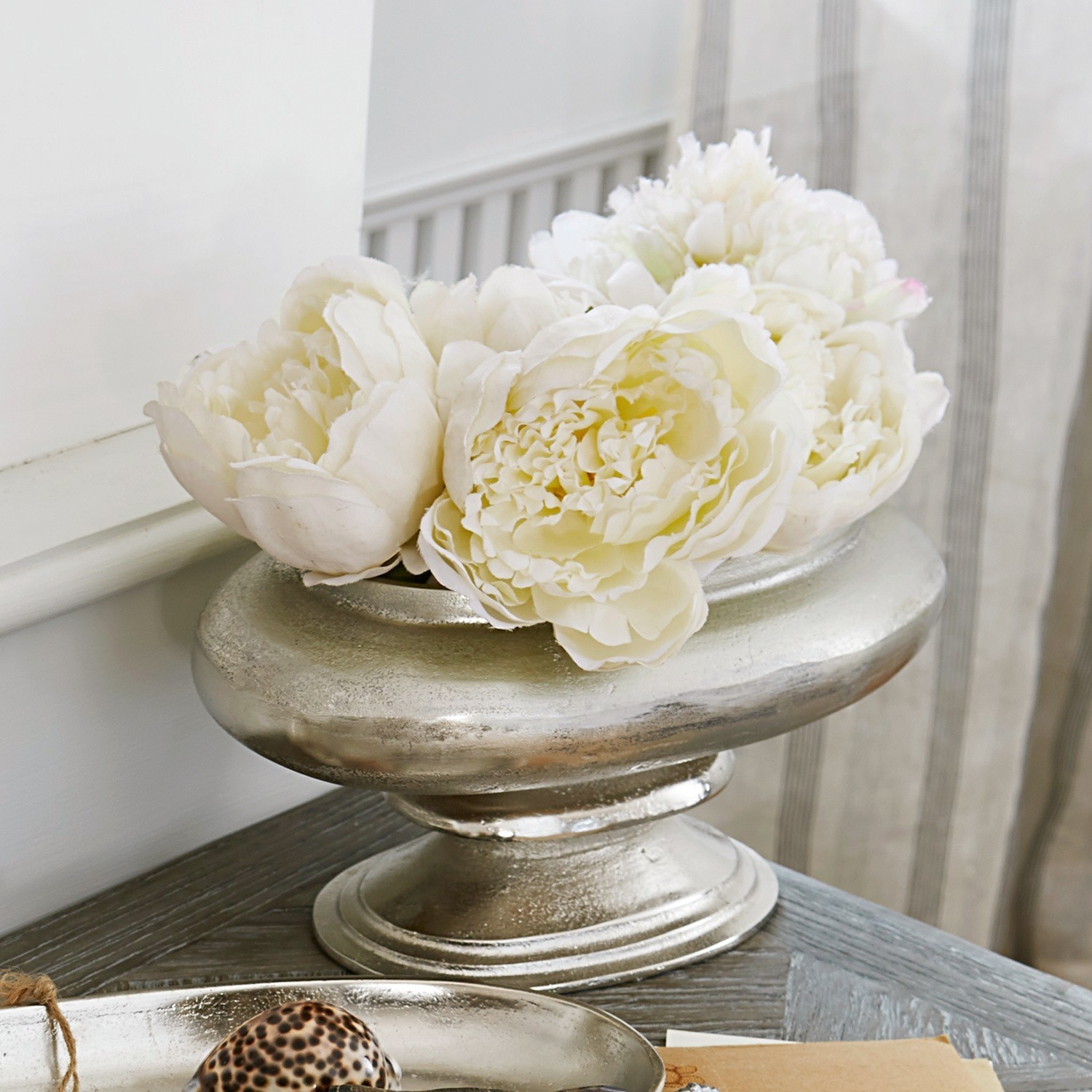 Vase Loyère Coupe décorative en métal argenté avec fleurs blanches sur table en bois dans un salon