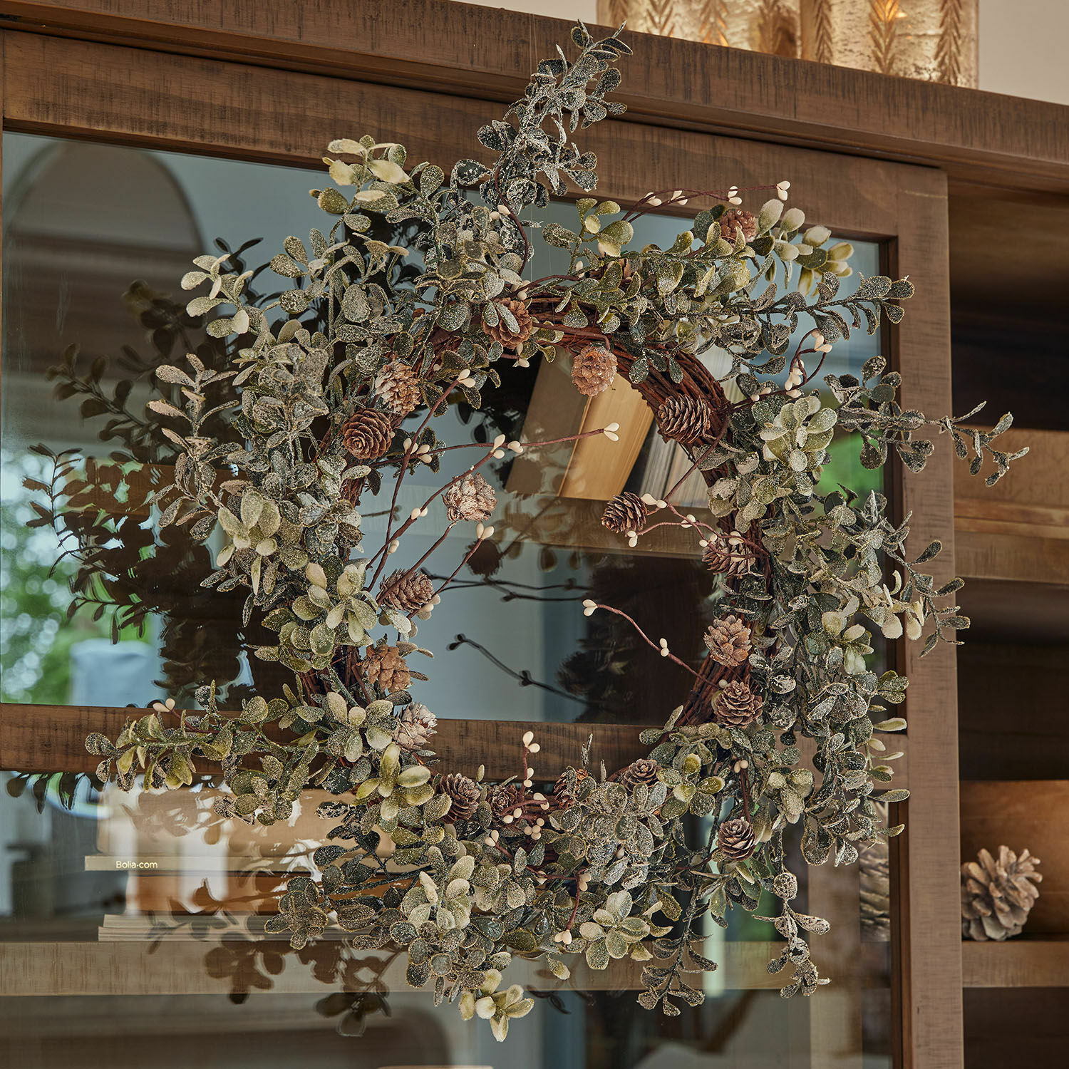 Couronne Veloume Couronne décorative en feuilles vertes et pommes de pin sur porte en bois, décoration festive