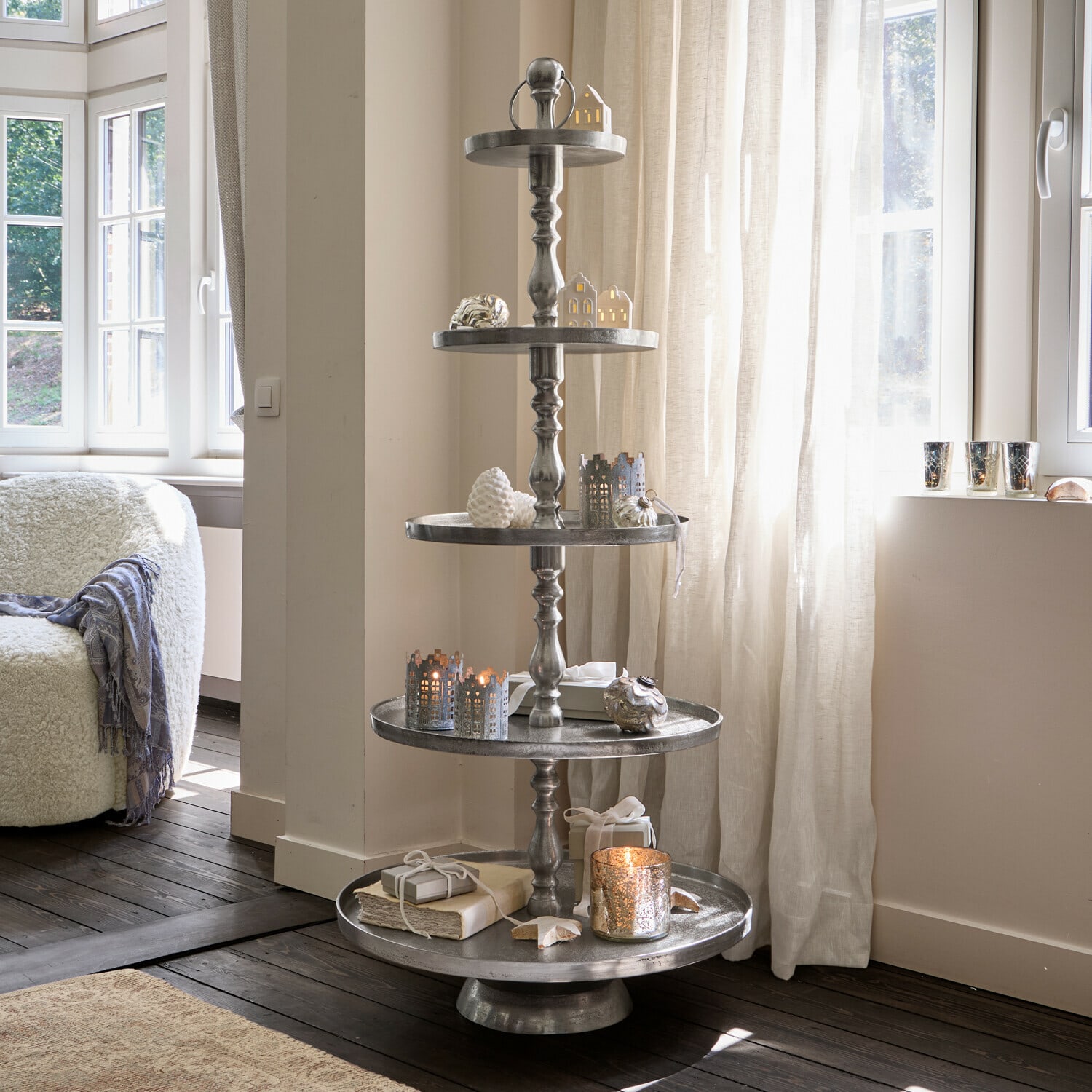 Présentoir à étages Magonie Décoration de Noël en métal à cinq niveaux avec branches vertes et boules dorées dans un salon