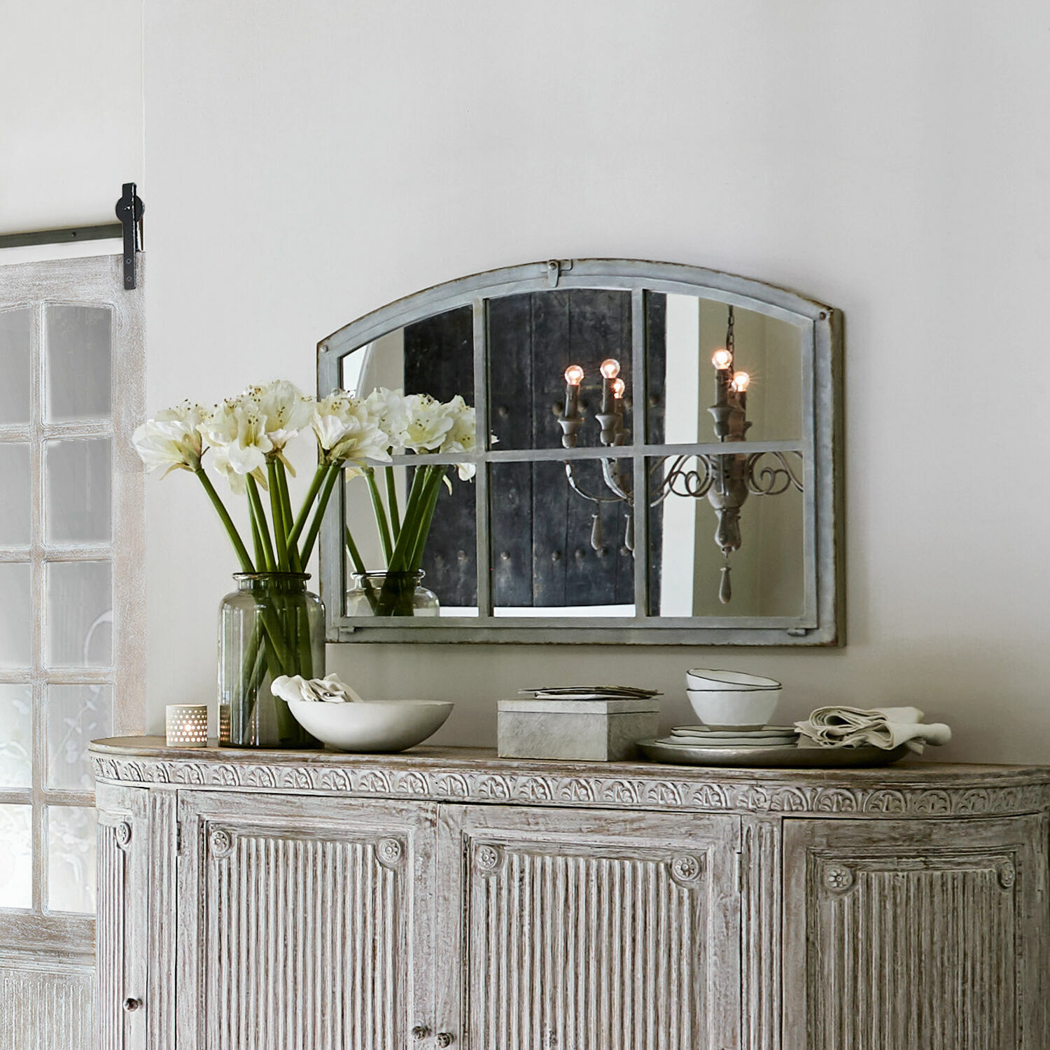 Miroir Bayaert Buffet en bois rustique blanc vieilli avec miroir et décorations sur le dessus dans un intérieur clair