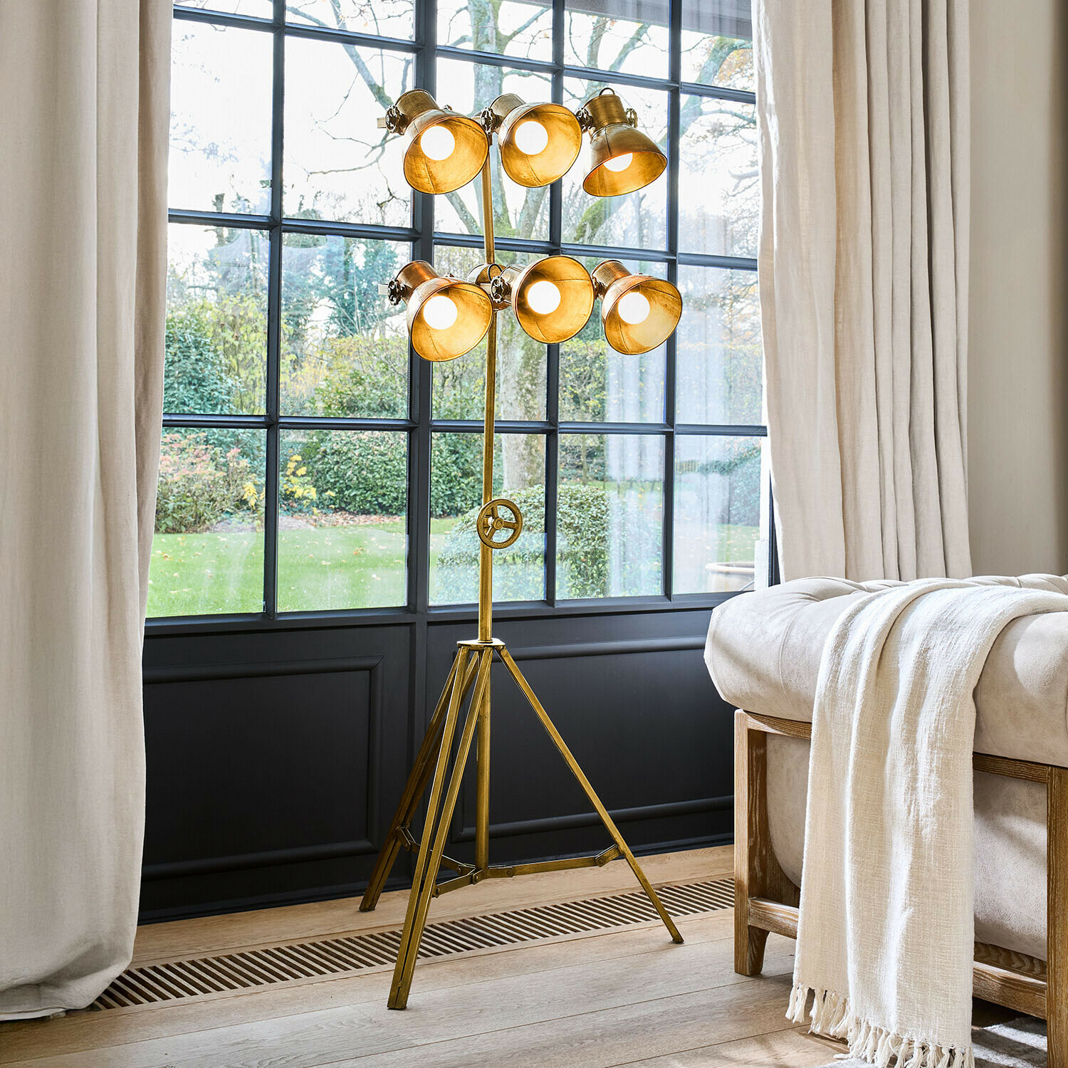 Lampadaire Venshire Lampadaire sur trépied en métal doré avec six abat-jours orientables dans un salon lumineux