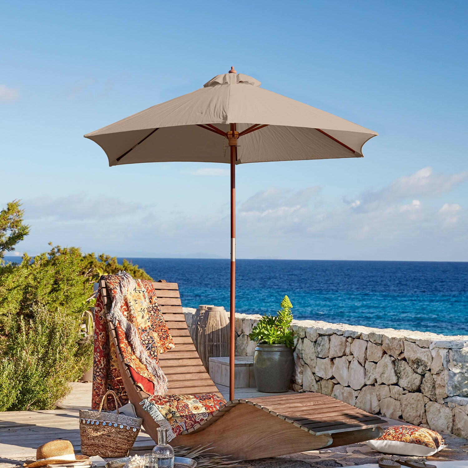 Parasol Enfield Chaise longue en bois avec parasol beige et plaid coloré au bord de la mer, mobilier de terrasse