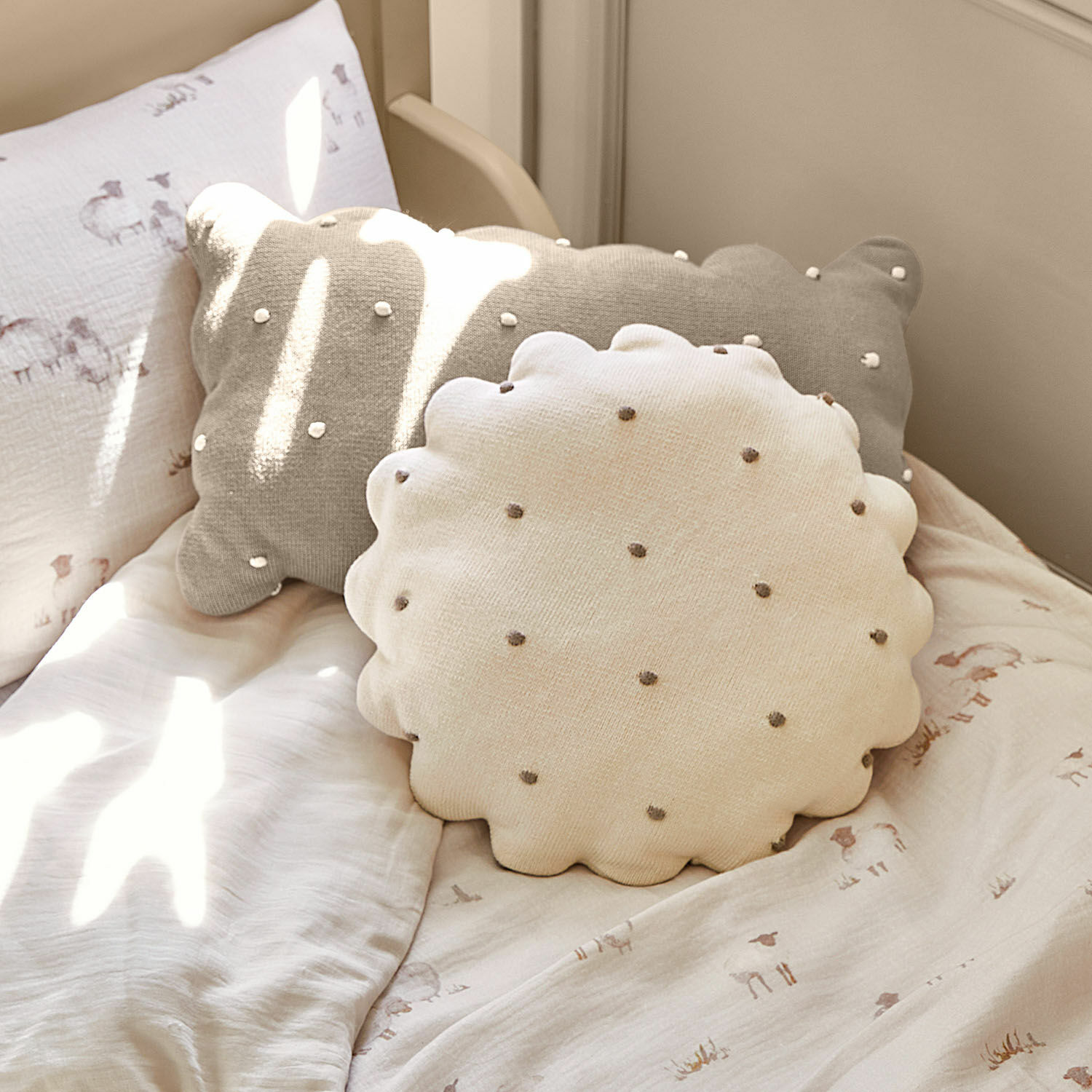Lot de 2 coussins Saphie Coussin décoratif rond et rectangulaire en coton beige et gris sur un lit clair