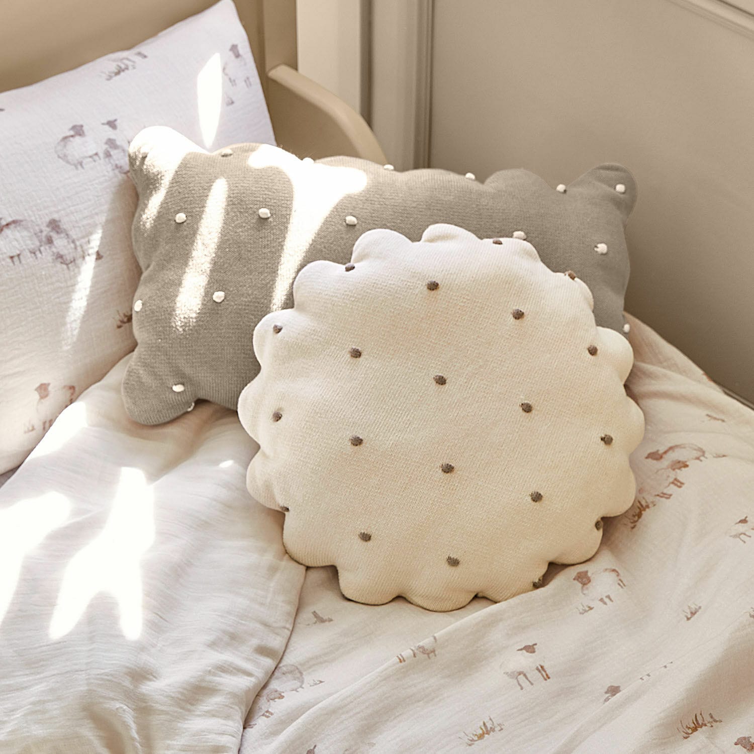 Lot de 2 coussins Saphie Coussin décoratif rond et rectangulaire en coton beige et gris sur un lit clair