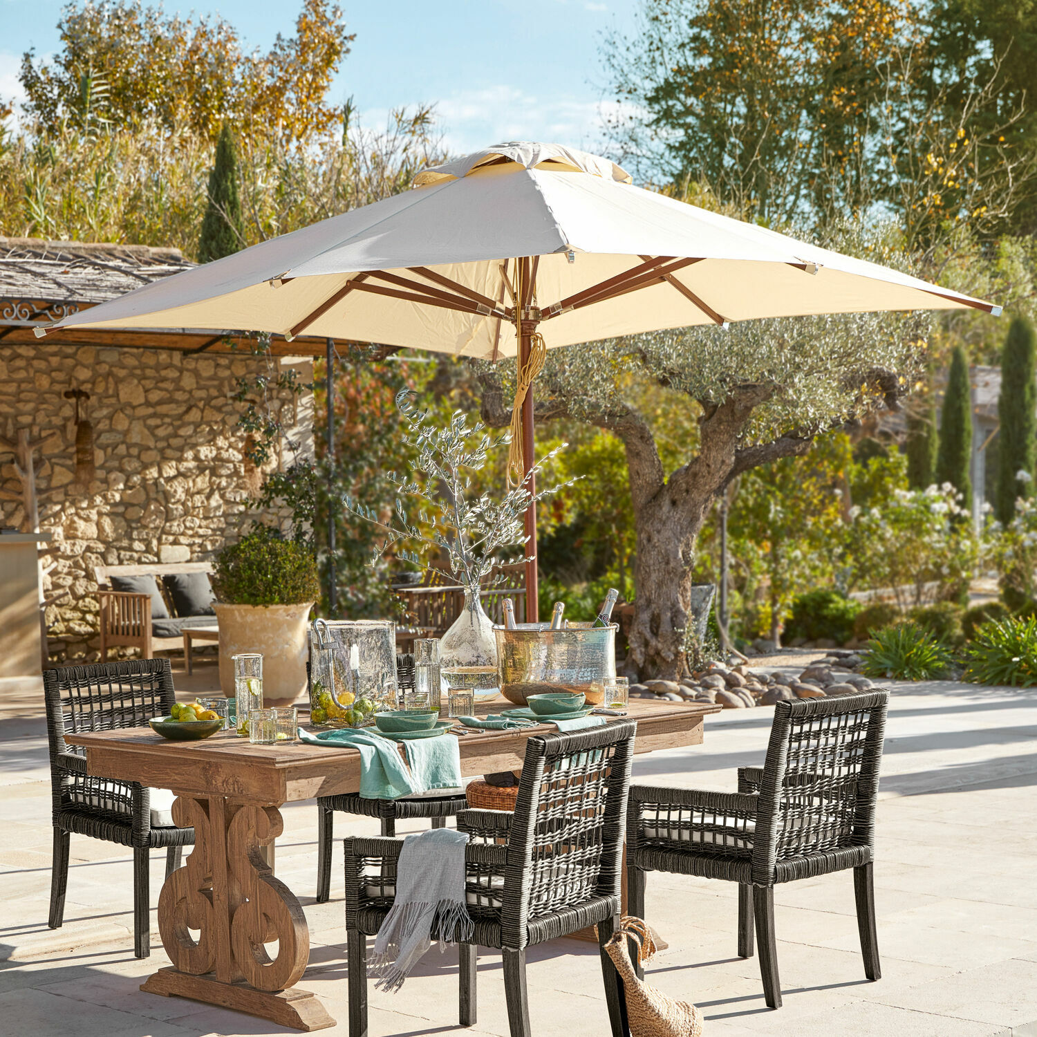 Parasol Brent Ensemble de mobilier de jardin avec table en bois et chaises en rotin noir sous un parasol beige