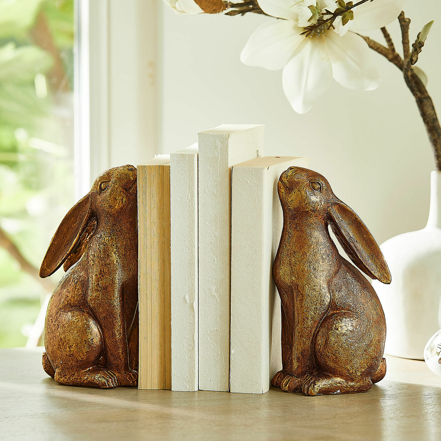 Lot de 2 serre-livres Turexil Paire de serre-livres décoratifs en forme de lapins en métal brun sur une table en bois