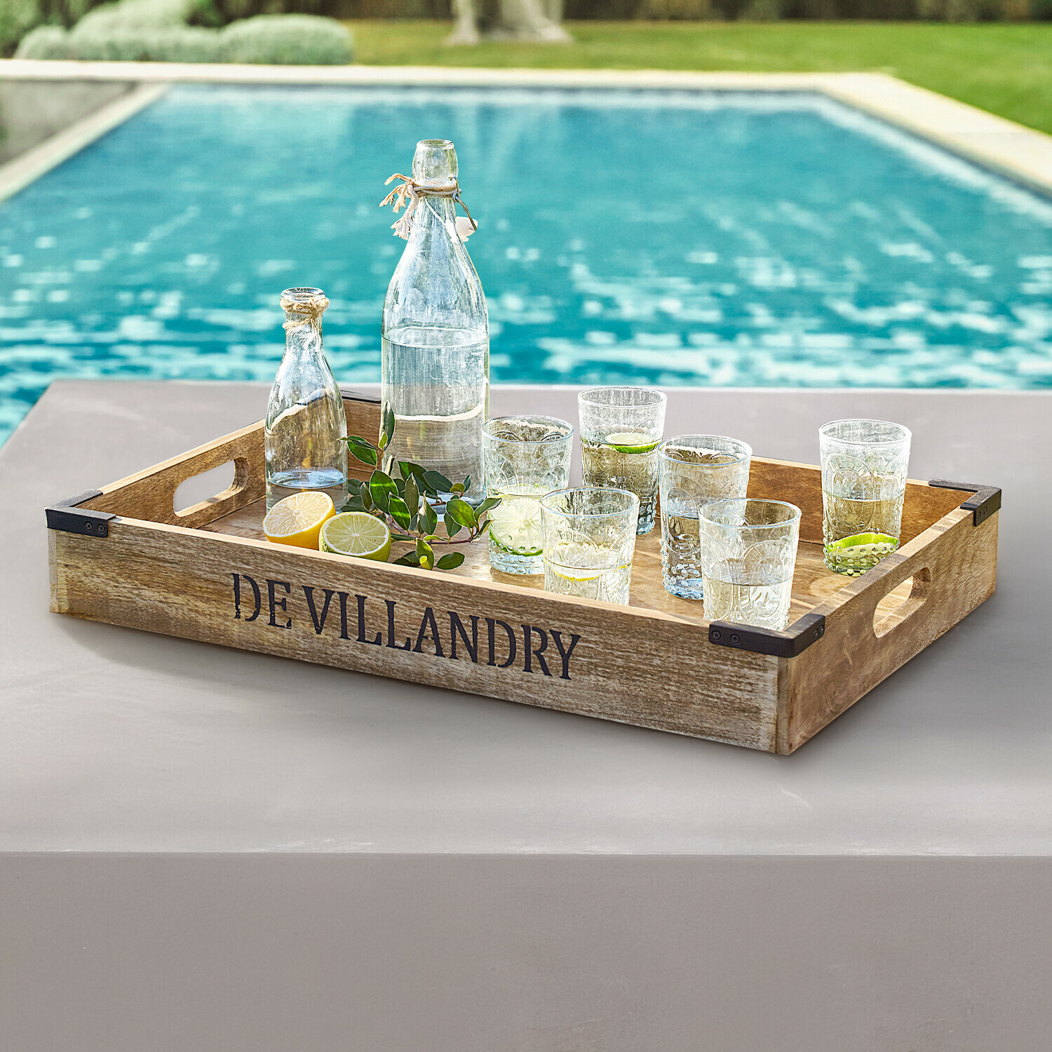 Plateau Villandry Plateau en bois DE VILLANDRY avec bouteilles et verres transparents au bord de la piscine, ambiance estivale