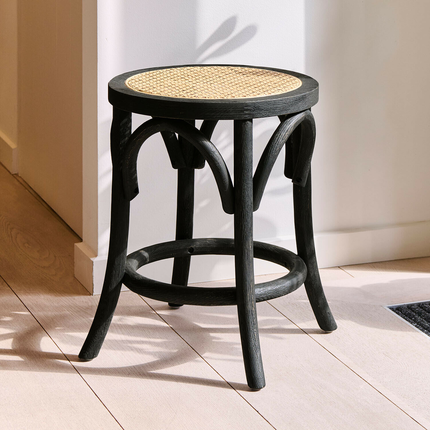 Tabouret Kary Tabouret noir en bois avec assise ronde en cannage, meuble moderne pour intérieur élégant