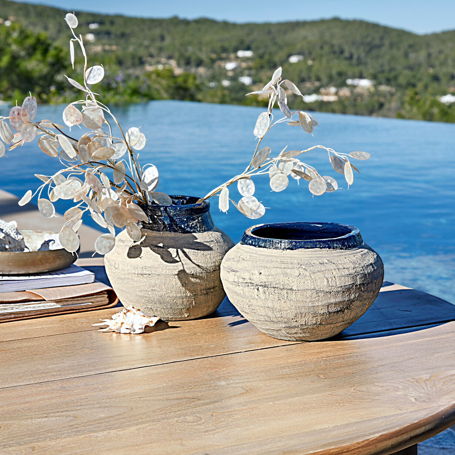 Lot de 2 vases Dolciaro Deux vases en céramique beige avec finition bleue sur une table en bois près de la piscine