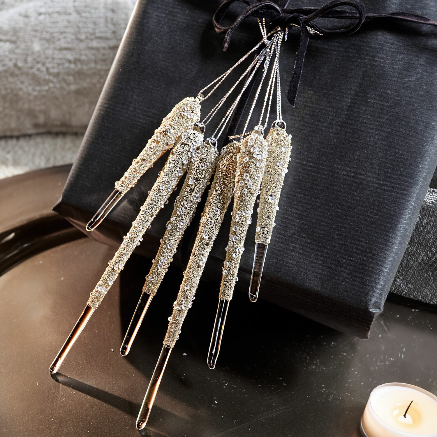 Lot de 6 décorations à suspendre Roussac Ensemble de six glaçons décoratifs en verre doré avec paillettes sur fond noir, décoration de Noël