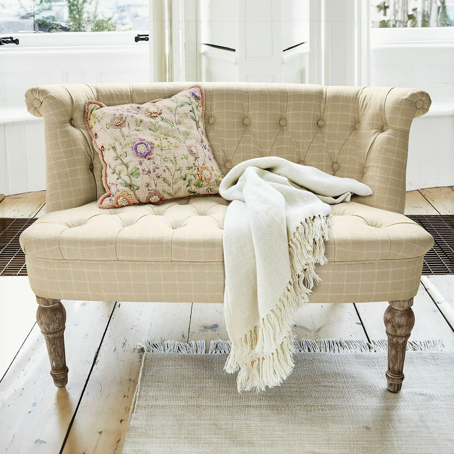 Canapé Weralin Canapé beige en tissu avec pieds en bois, coussin décoratif et plaid crème sur un tapis clair