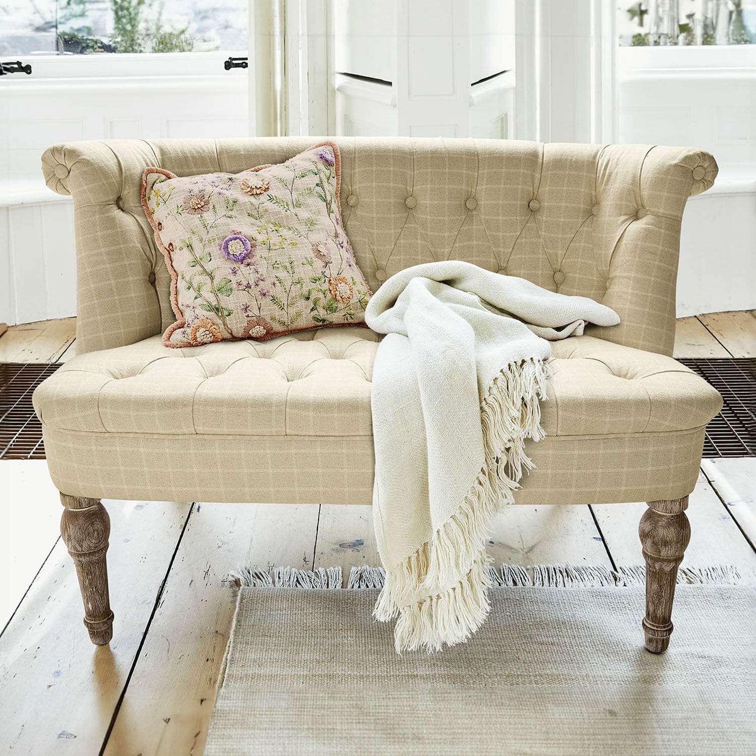Canapé Weralin Canapé beige en tissu avec pieds en bois, coussin décoratif et plaid crème sur un tapis clair