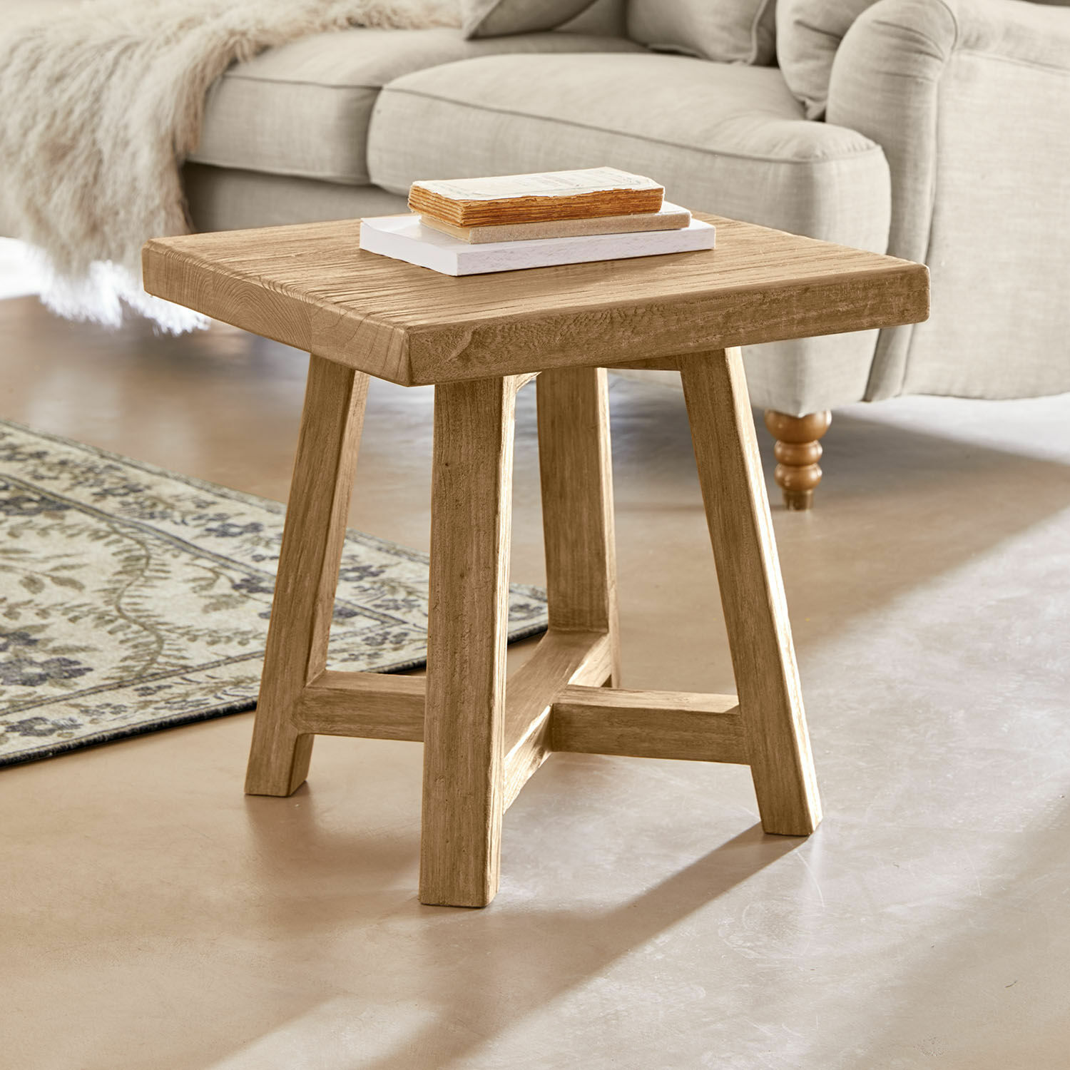 Table d'appoint Eldonbury Table basse carrée en bois naturel devant un canapé beige et un tapis décoratif