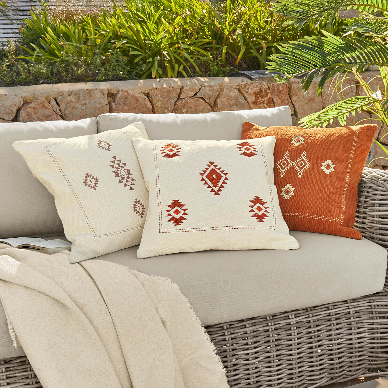 Ensemble de trois coussins décoratifs en coton crème et orange avec motifs géométriques pour salon extérieur