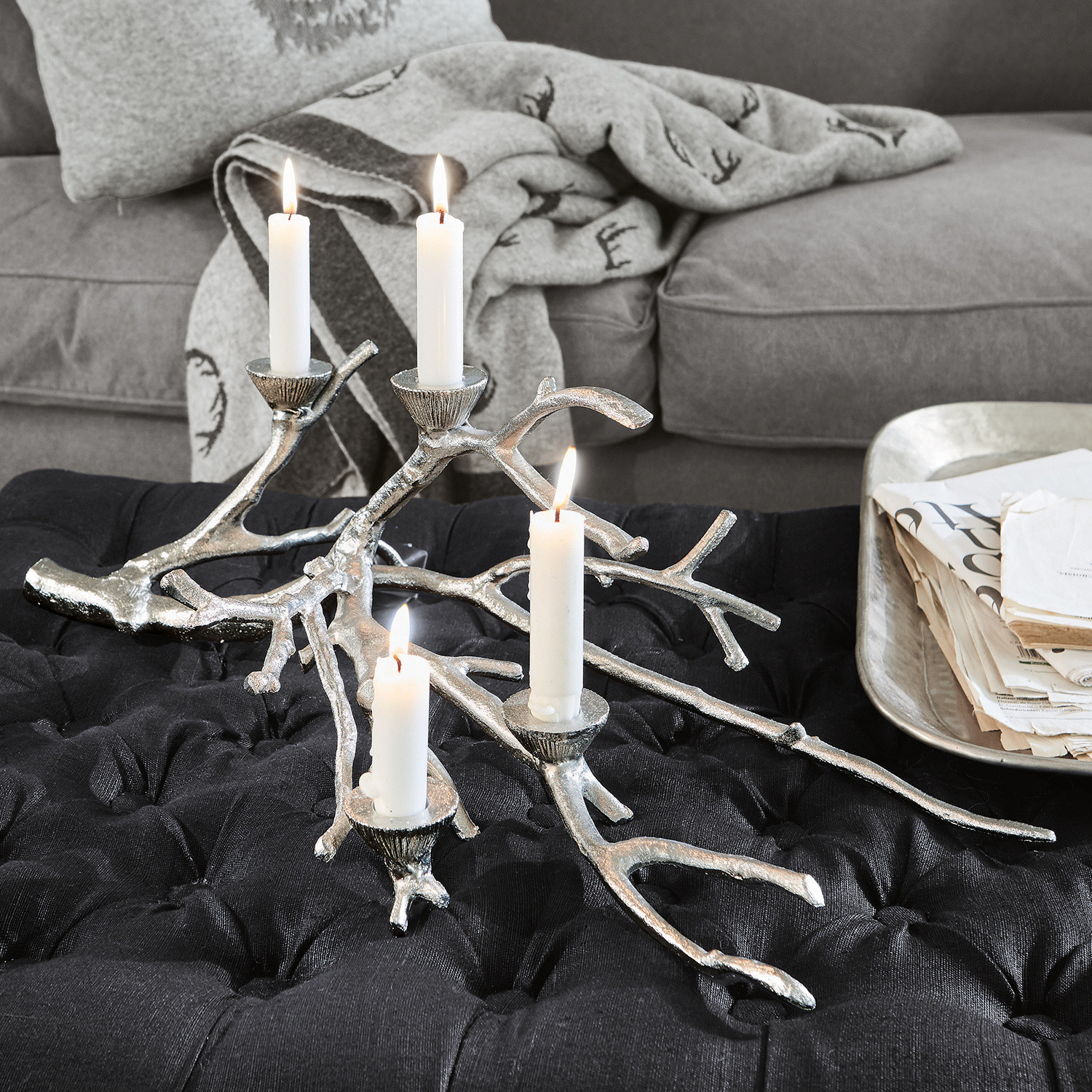 Chandelier Palle Chandelier en métal argenté en forme de branche posé sur un tissu noir dans un salon