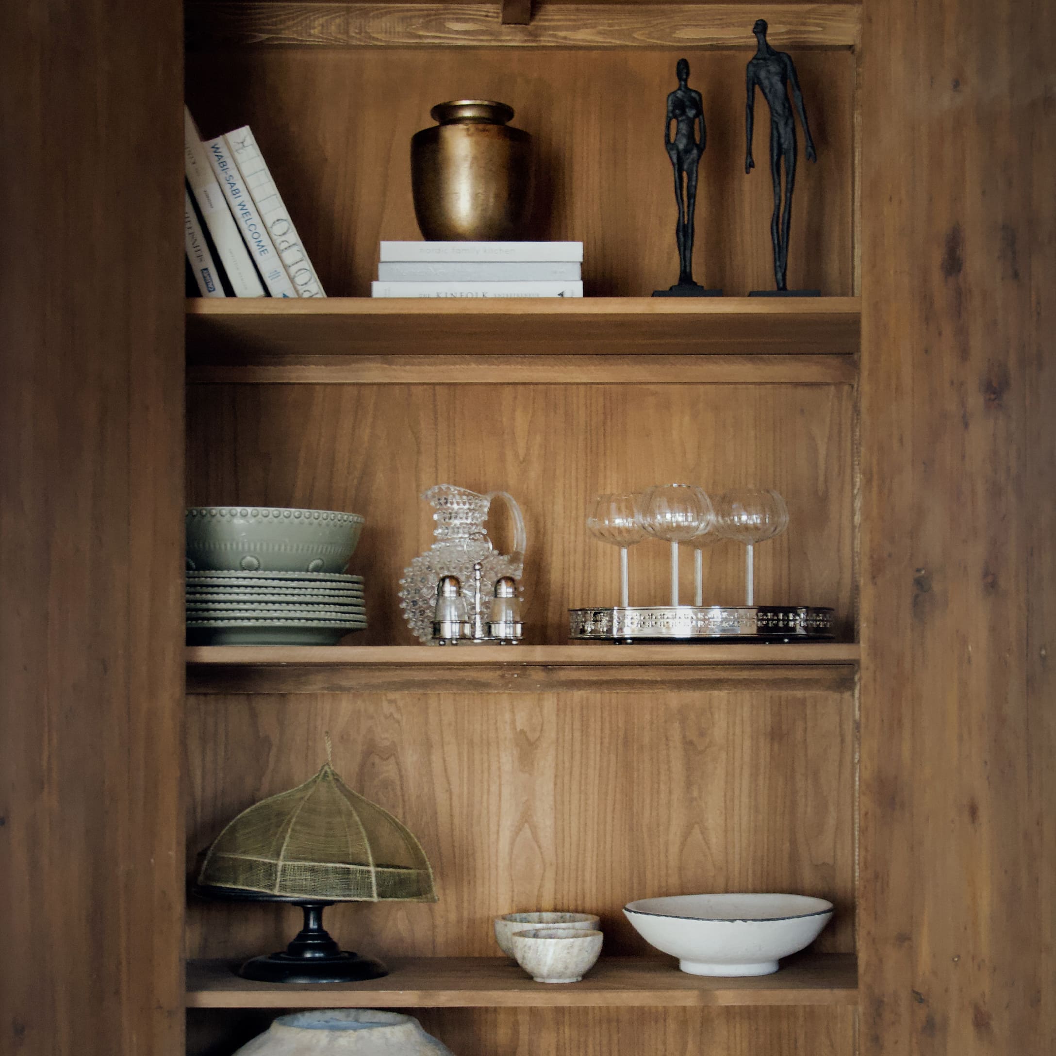 Étagère en bois avec objets décoratifs en verre, céramique et sculptures artistiques vintage