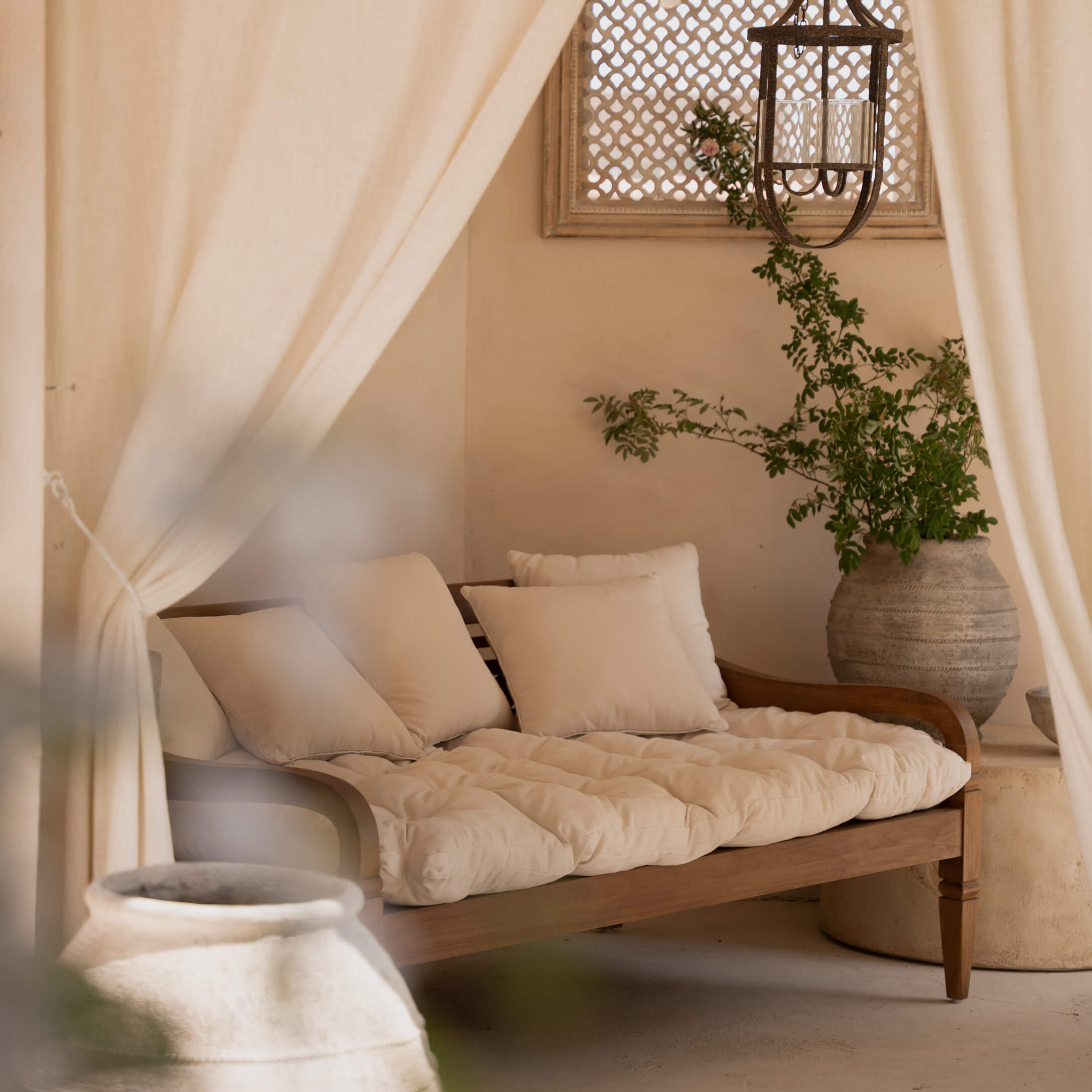 Canapé en bois avec coussins crème et matelas moelleux dans un intérieur naturel et chaleureux