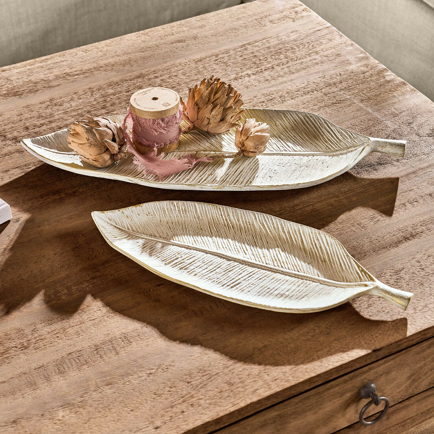 Lot de 2 plateaux Valmorin Assiettes décoratives en céramique forme feuille couleur crème posées sur une table en bois