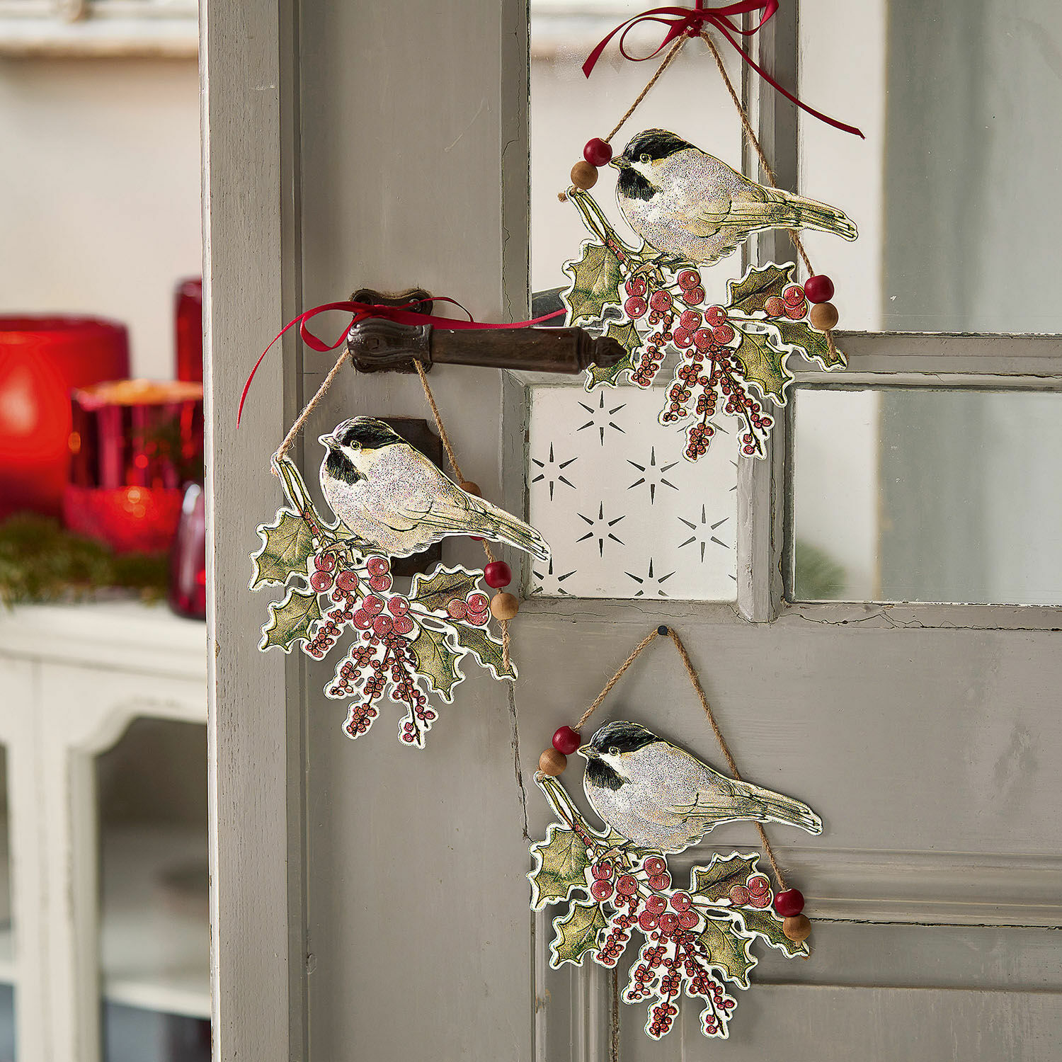 Lot de 3 décorations à suspendre Eliza Décorations de Noël avec oiseaux et baies rouges suspendues à une porte grise, ambiance festive
