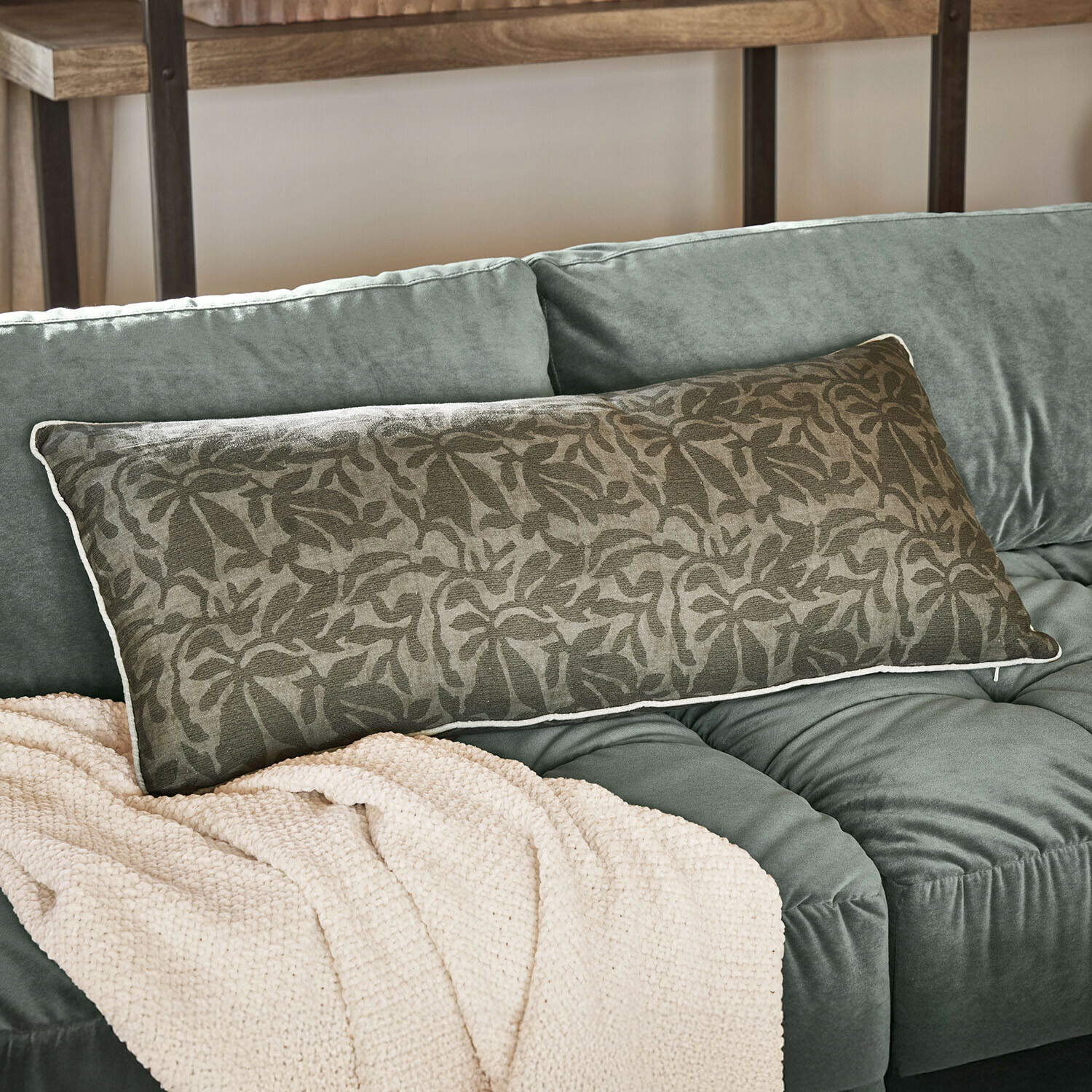 Coussin Rosamound Coussin décoratif allongé vert avec motif floral sur canapé vert doux avec couverture beige