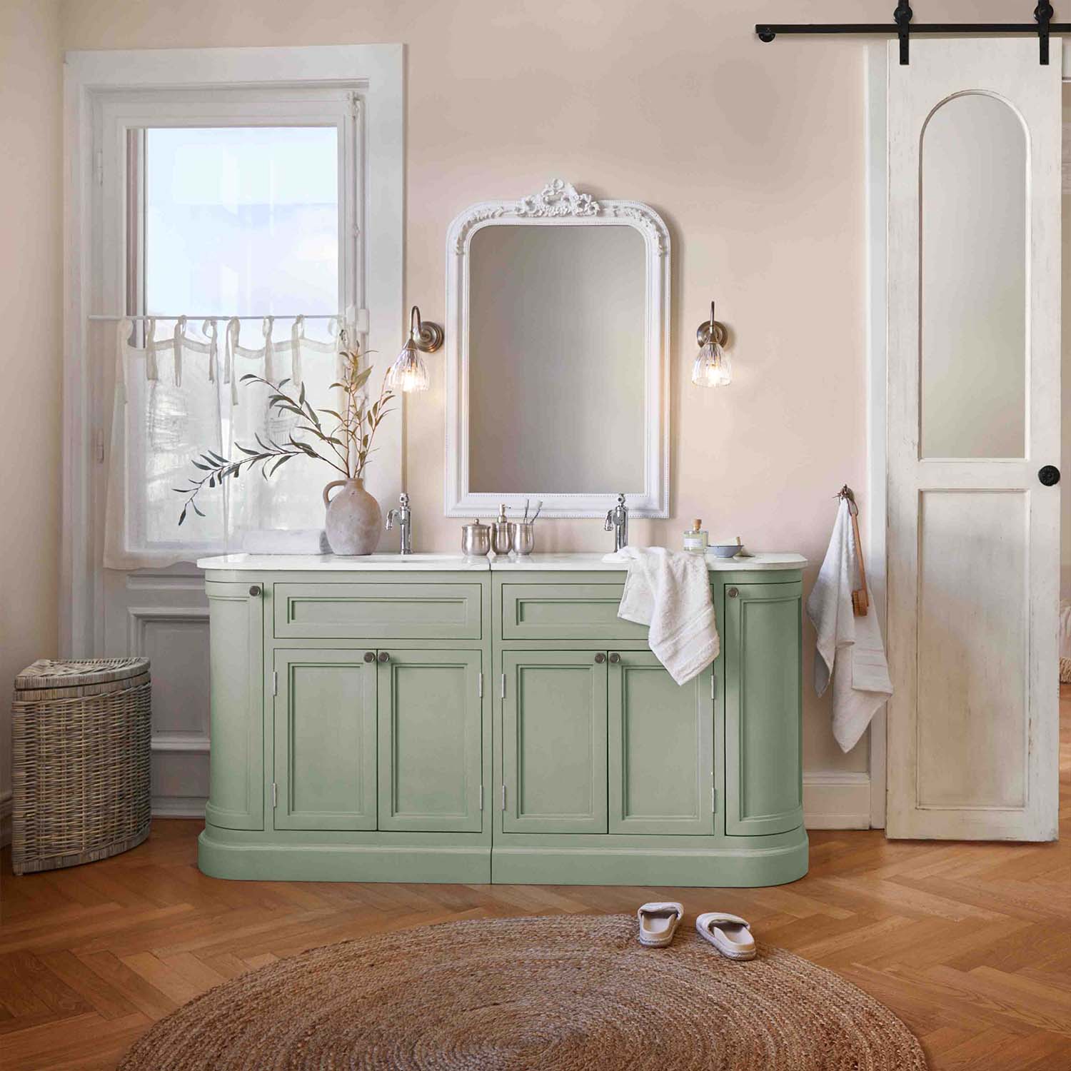 Meuble de salle de bain vert avec plan blanc et miroir vintage, ambiance douce et naturelle