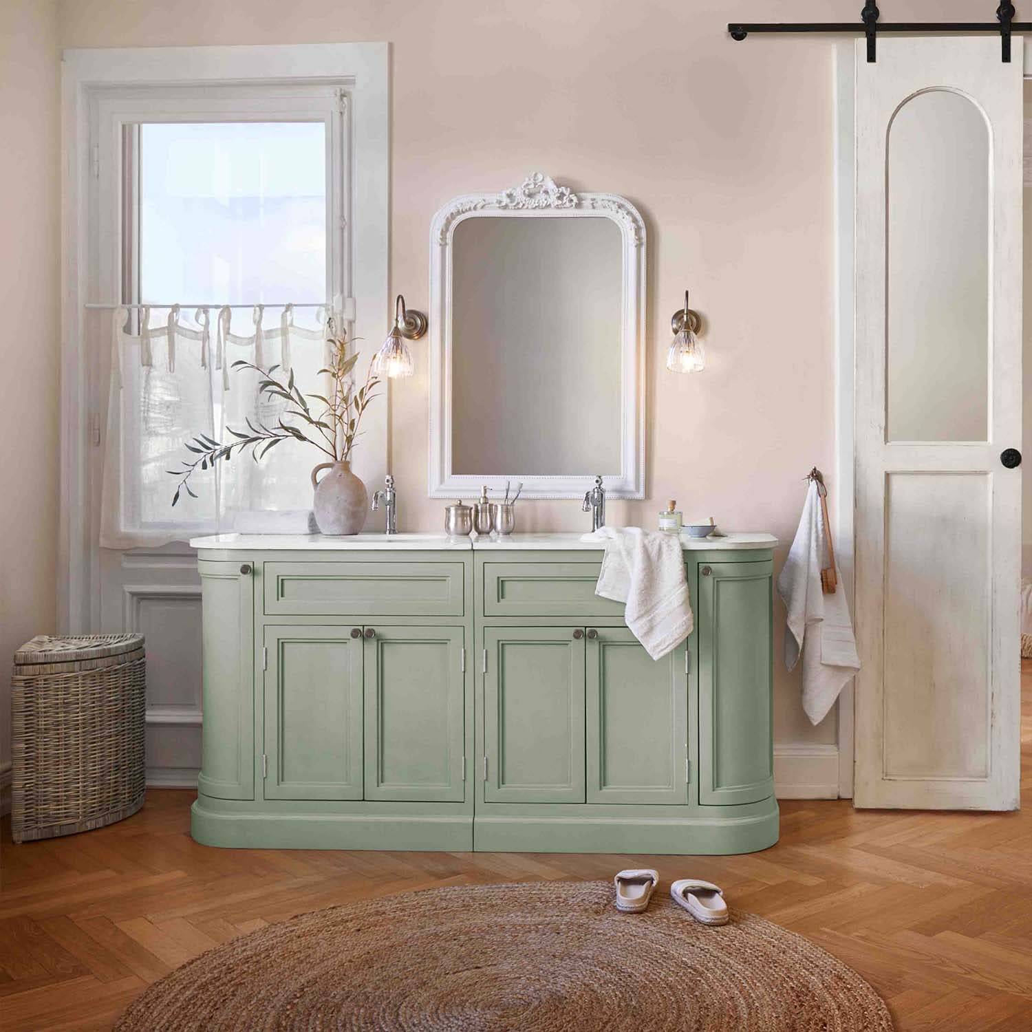 Meuble de salle de bain vert avec plan blanc et miroir vintage, ambiance douce et naturelle