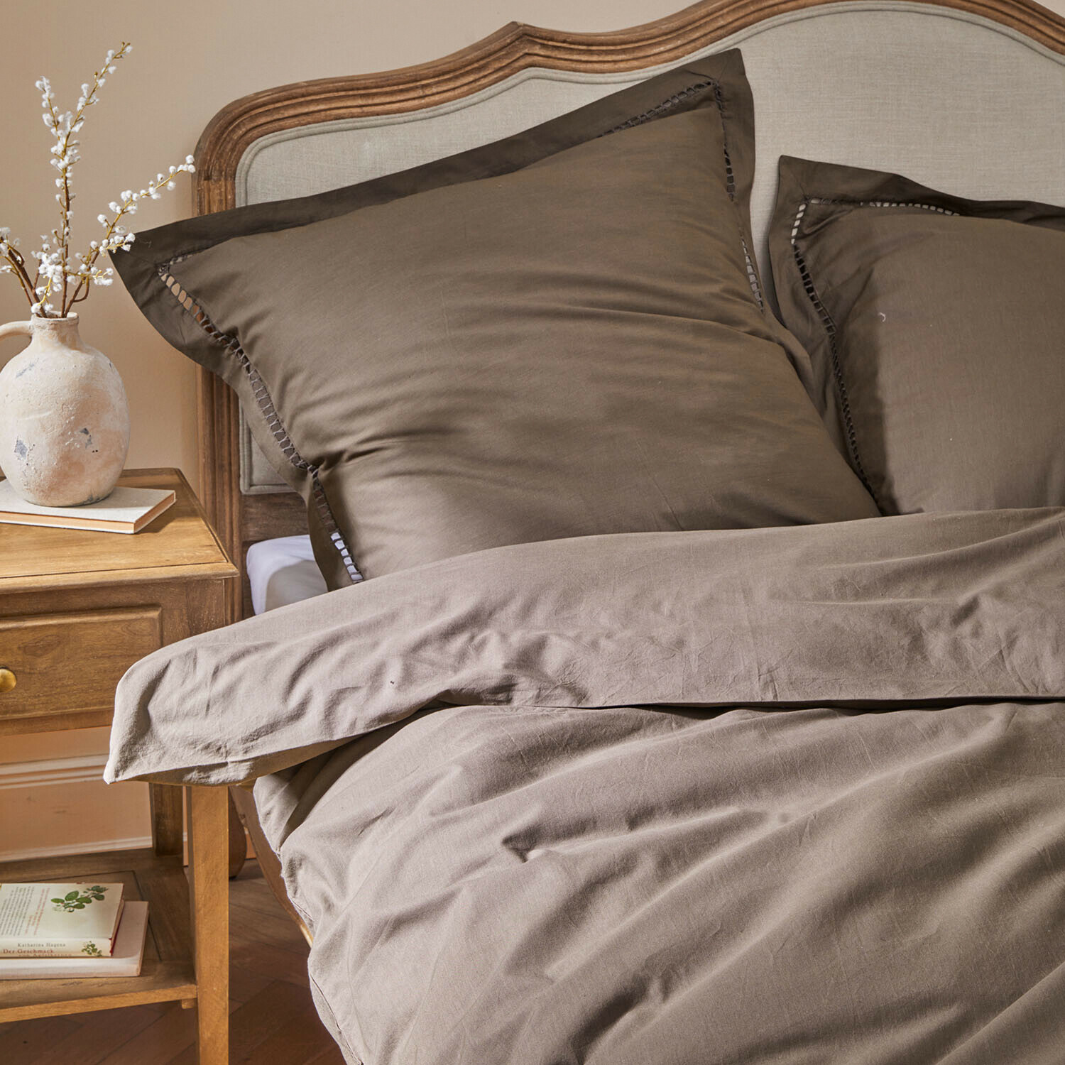 Parure de lit Belvero Parure de lit marron en coton sur un lit avec tête de lit en bois et table de nuit avec vase