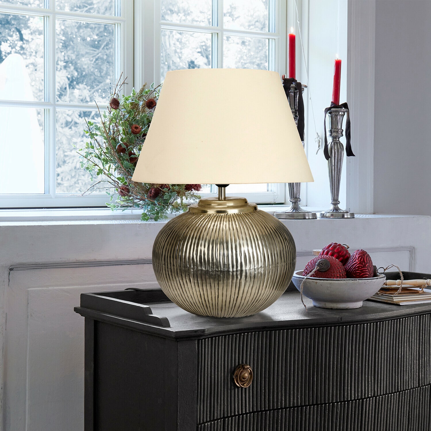 Lampe à poser Rosélune Lampe de table en laiton avec abat-jour crème sur commode noire dans une pièce lumineuse