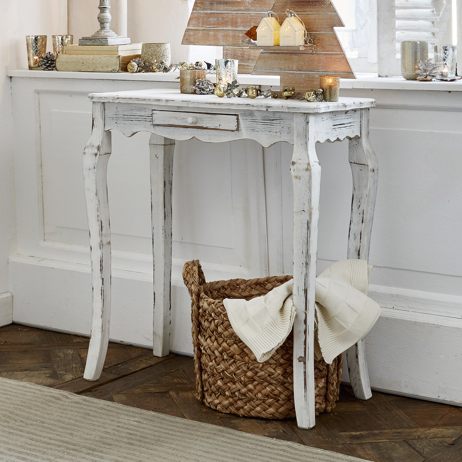 Table en bois blanc style vintage avec tiroir, décorations de Noël et panier en osier au sol