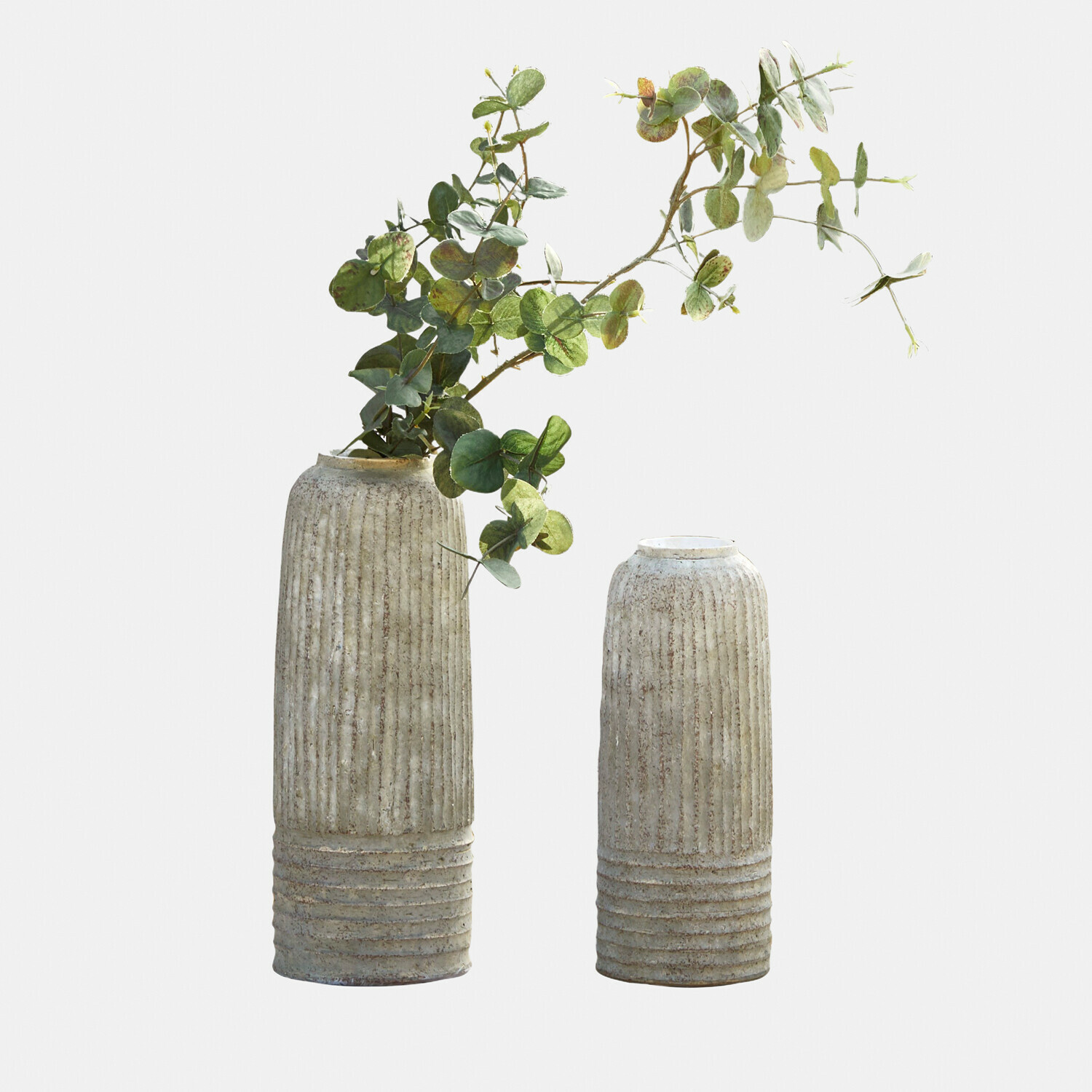 Lot de 2 vases Bellonas Deux vases en céramique beige texturée, l'un avec des feuilles d'eucalyptus vertes, décoration intérieure moderne