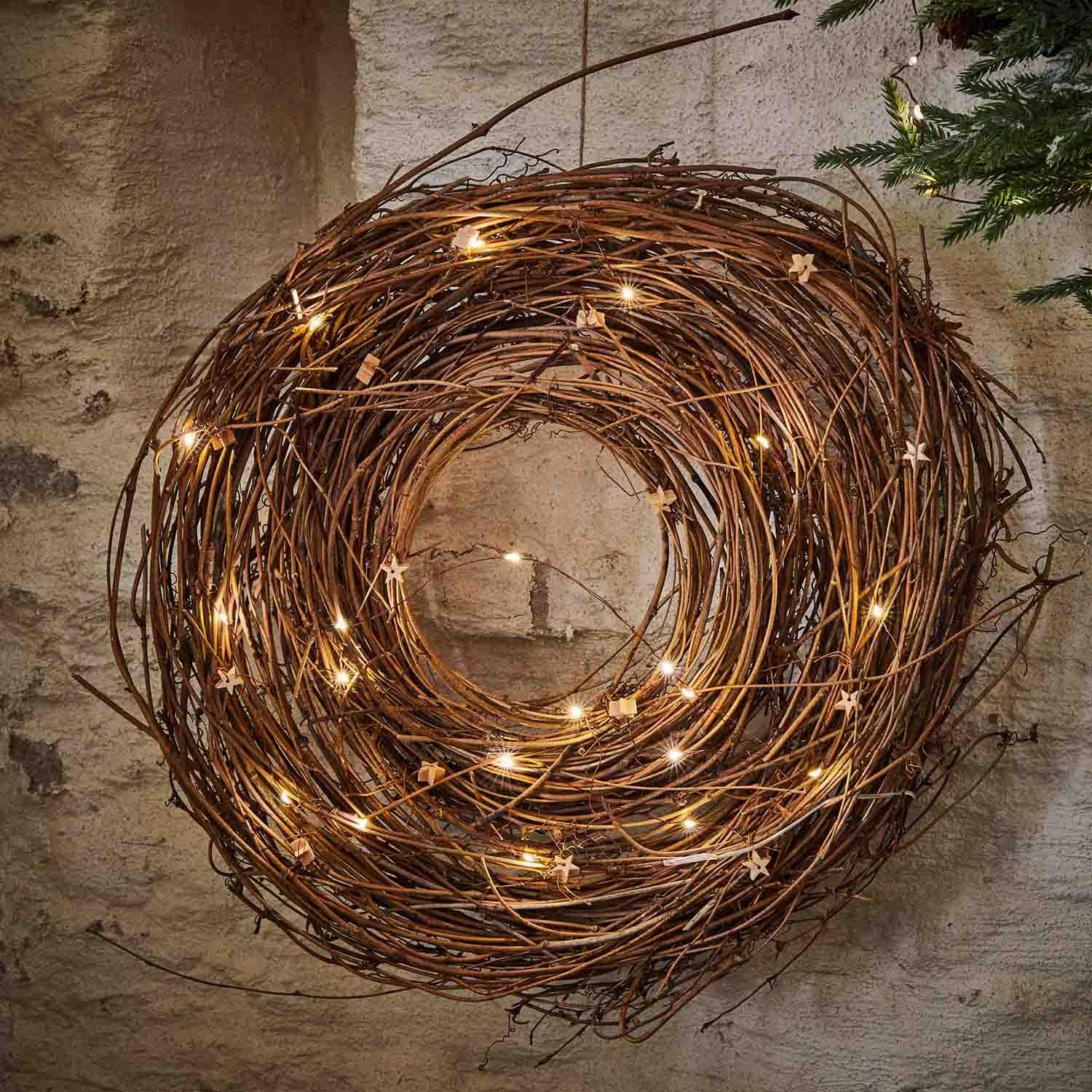 Couronne décorative en branches naturelles avec guirlande lumineuse LED suspendue au mur