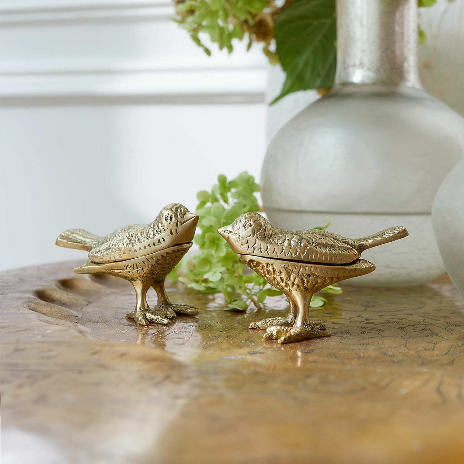 Lot de 2 oiseaux décoratifs Fairydell Deux oiseaux décoratifs dorés en métal sur une table en bois, décoration intérieure élégante