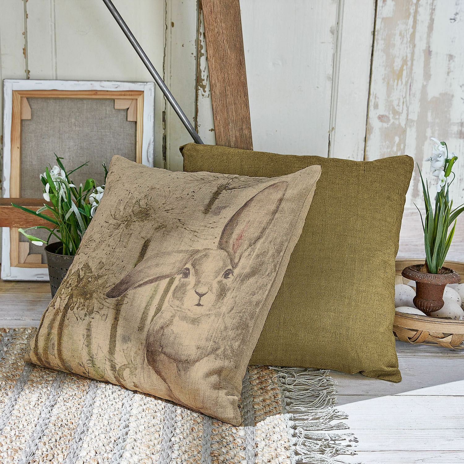 Lot de 2 housses de coussins Milda Coussin beige avec impression de lapin et coussin vert décoratif sur tapis tressé