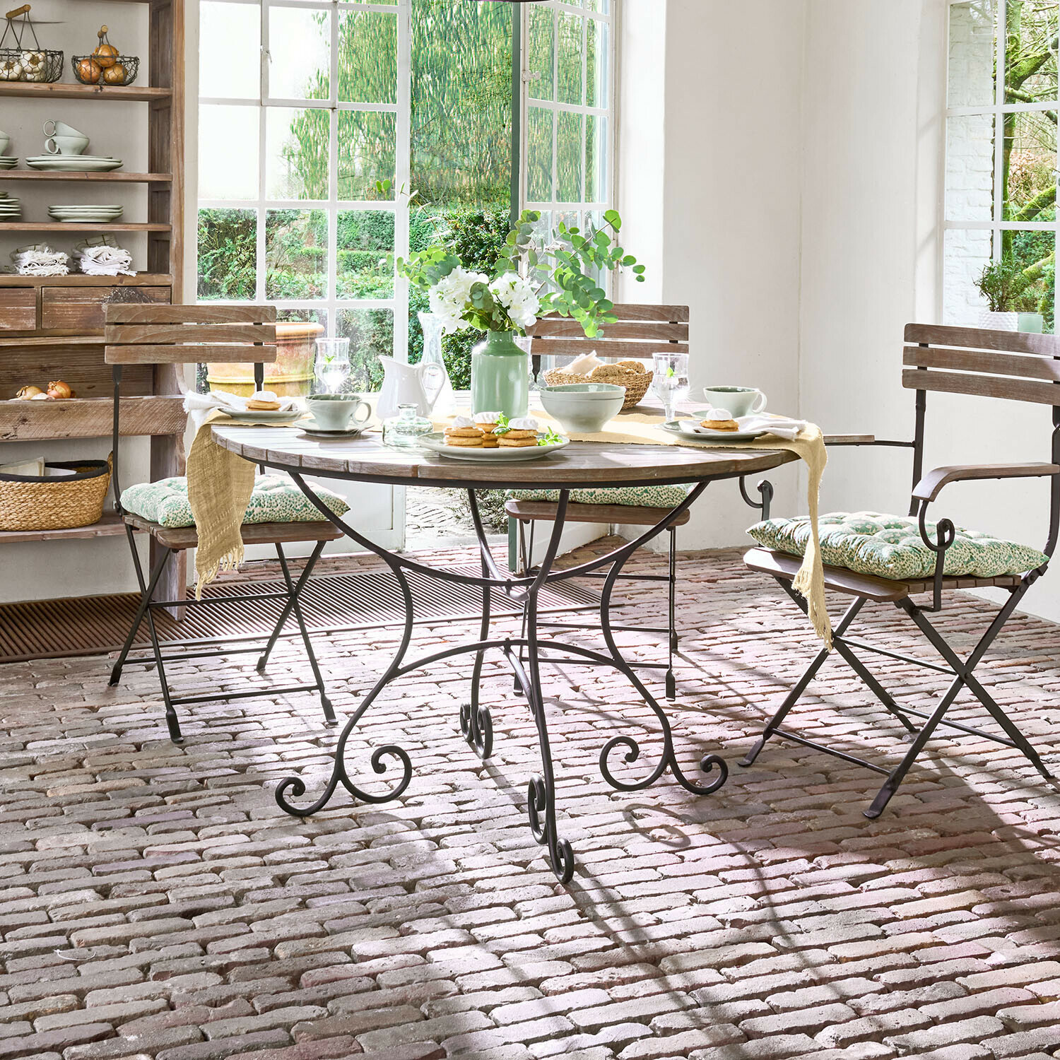 Table Arémont Table ronde en bois avec pieds en métal dans une salle à manger rustique avec chaises et décoration florale