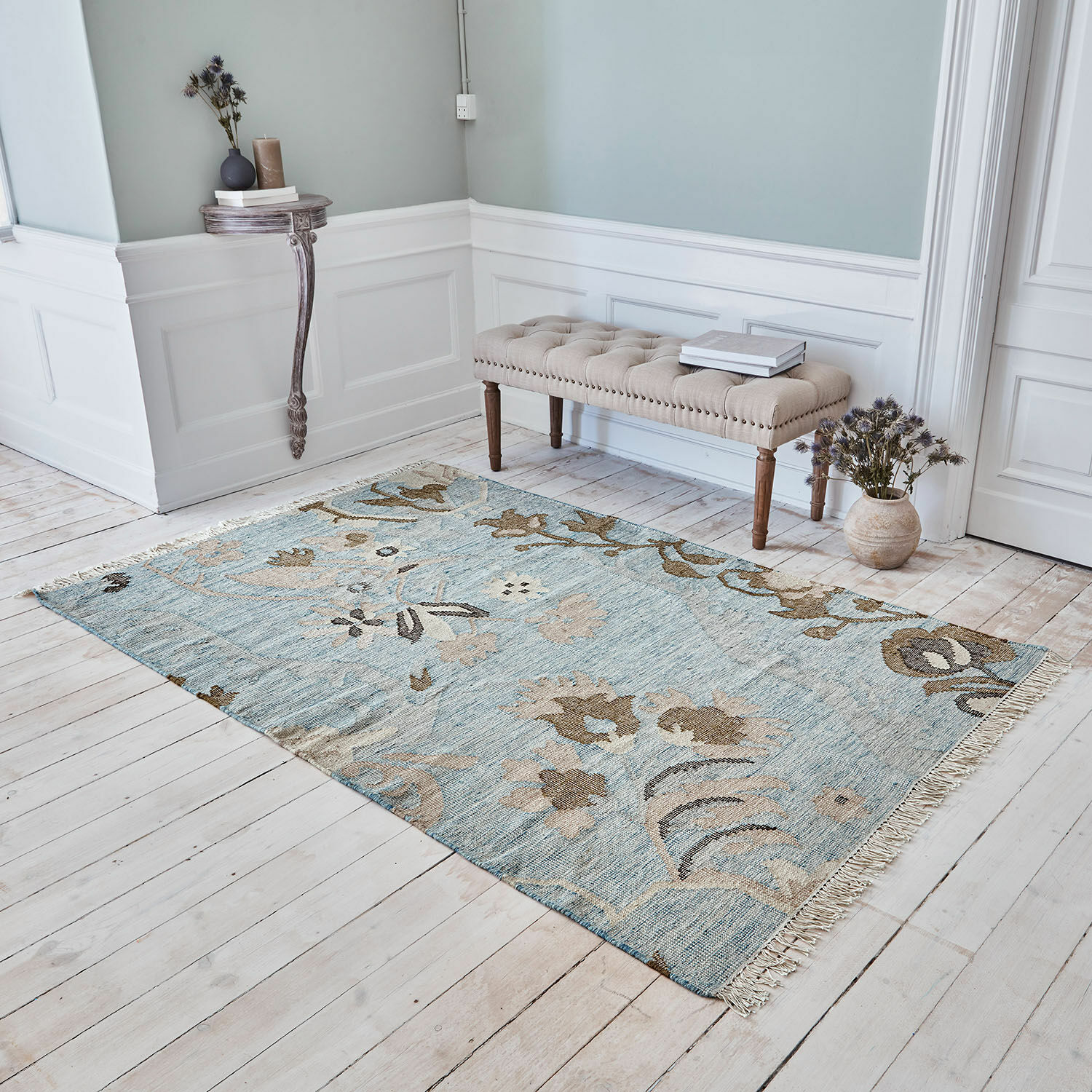 Tapis Nére Tapis à motif floral bleu et beige sur un sol en bois clair dans un intérieur élégant