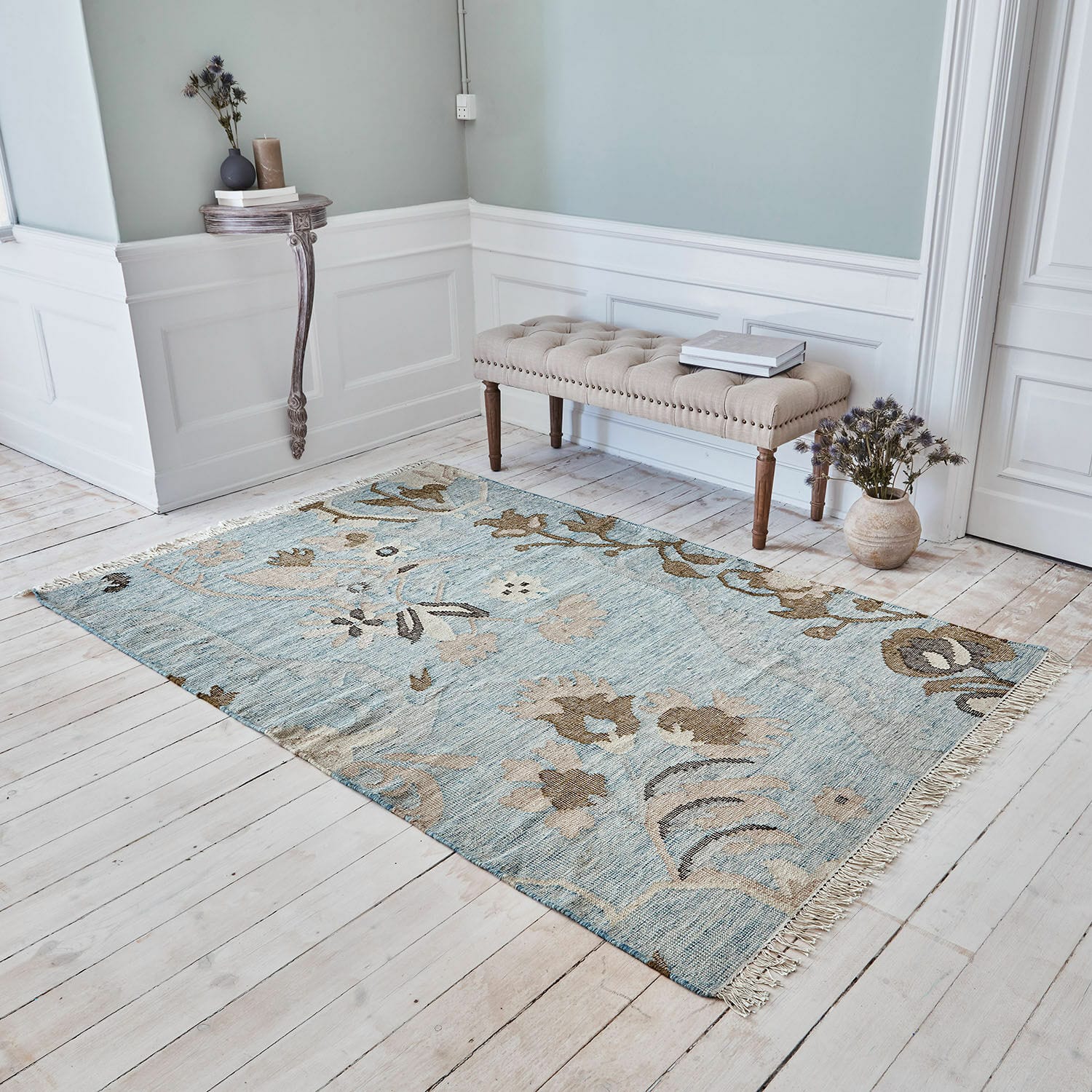 Tapis Nére Tapis à motif floral bleu et beige sur un sol en bois clair dans un intérieur élégant