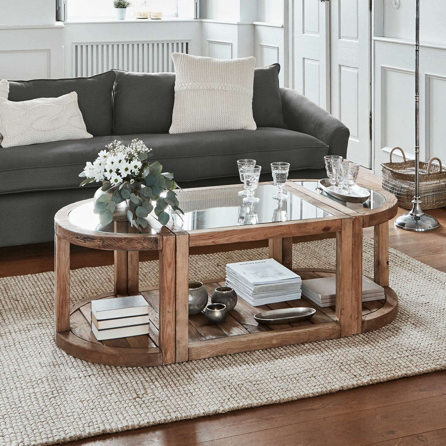 Table basse Hyllorian Table basse ovale en bois et verre sur tapis beige dans un salon moderne et lumineux