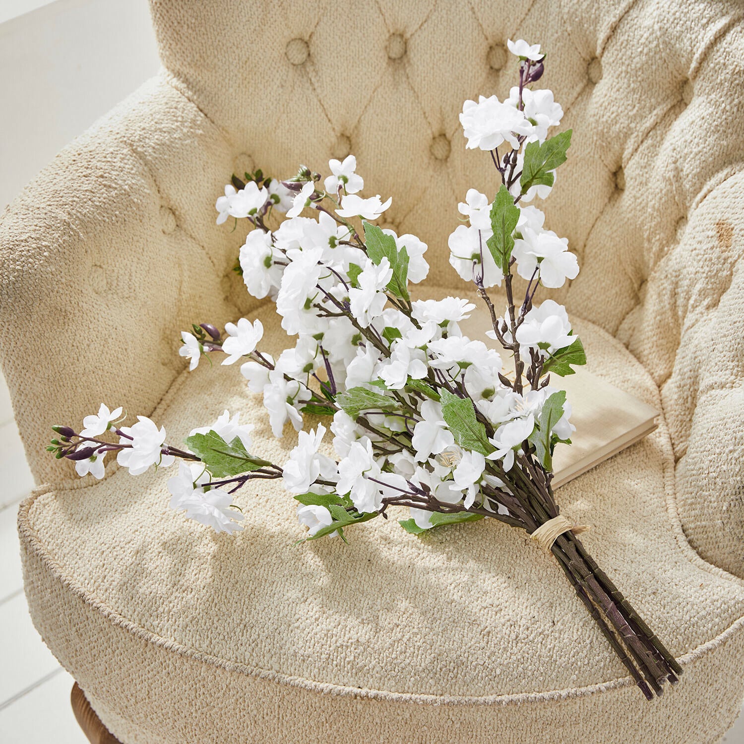 Lot de 6 fleurs décoratives Bellévaut Bouquet de fleurs blanches artificielles avec feuilles vertes sur fauteuil beige texturé
