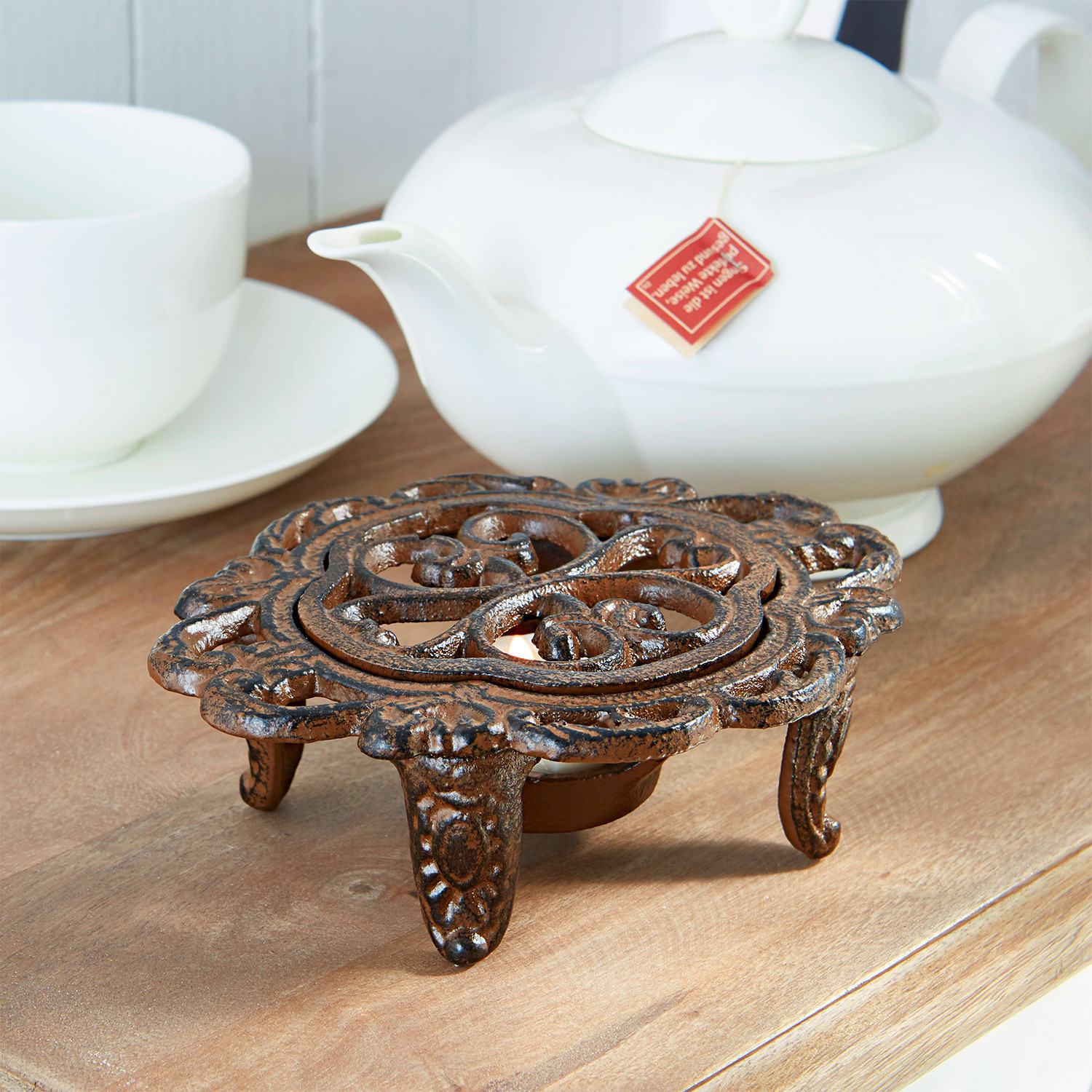 Chauffe-théière Florian Chauffe-théière en fonte brun décoratif sur table en bois avec porcelaine blanche