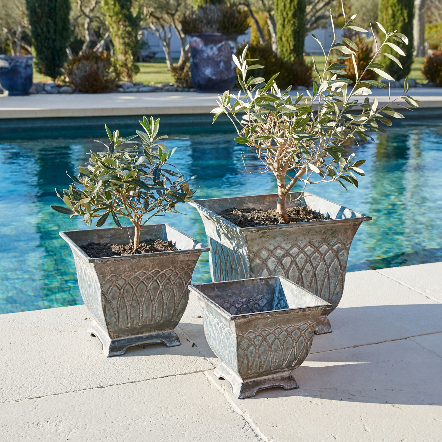 Lot de 3 cache-pots Klaireau Ensemble de trois pots en métal gris style vintage posés près d'une piscine