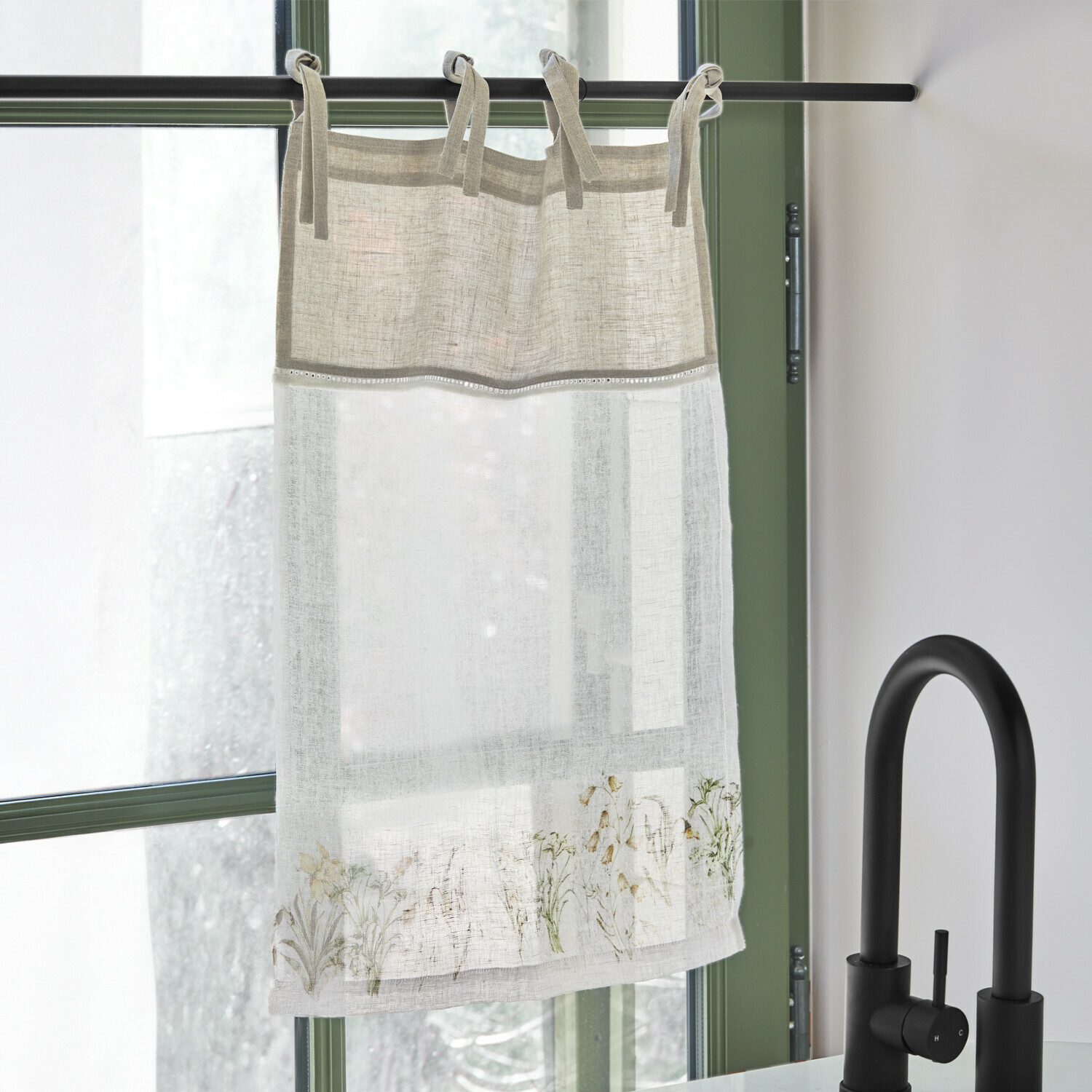 Brise-bise Lozere Rideau en lin beige et blanc avec motif floral délicat, suspendu sur une tringle noire près d'un robinet noir