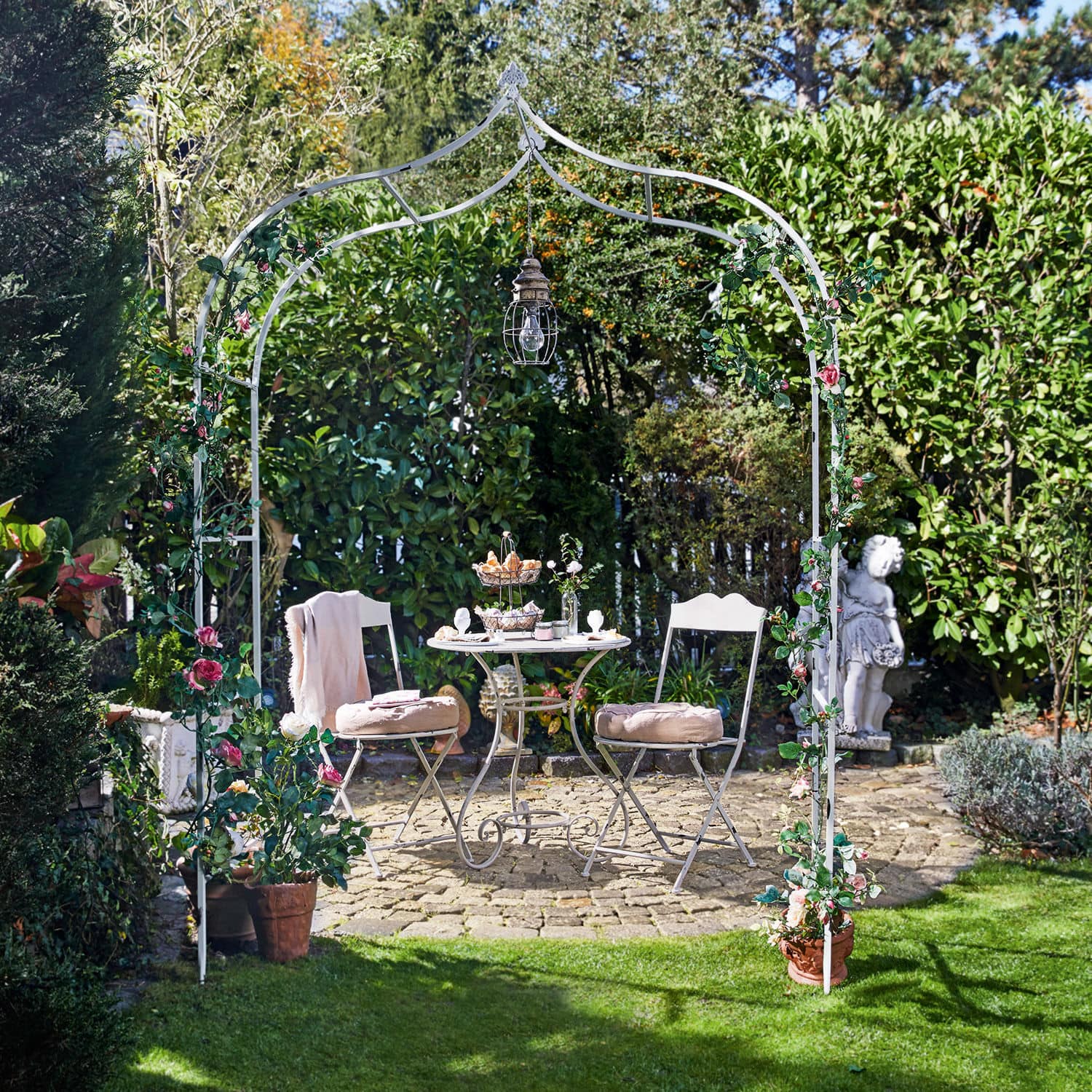 Arche à rosier Dimarus Arche de jardin en métal blanc avec fleurs roses et lampe suspendue, table et chaises sur patio en pierre