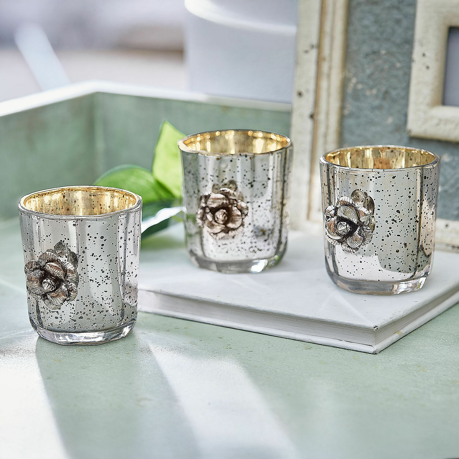 Lot de 3 photophores Alovix Ensemble de trois photophores en verre argenté avec intérieur doré et décoration florale métallique