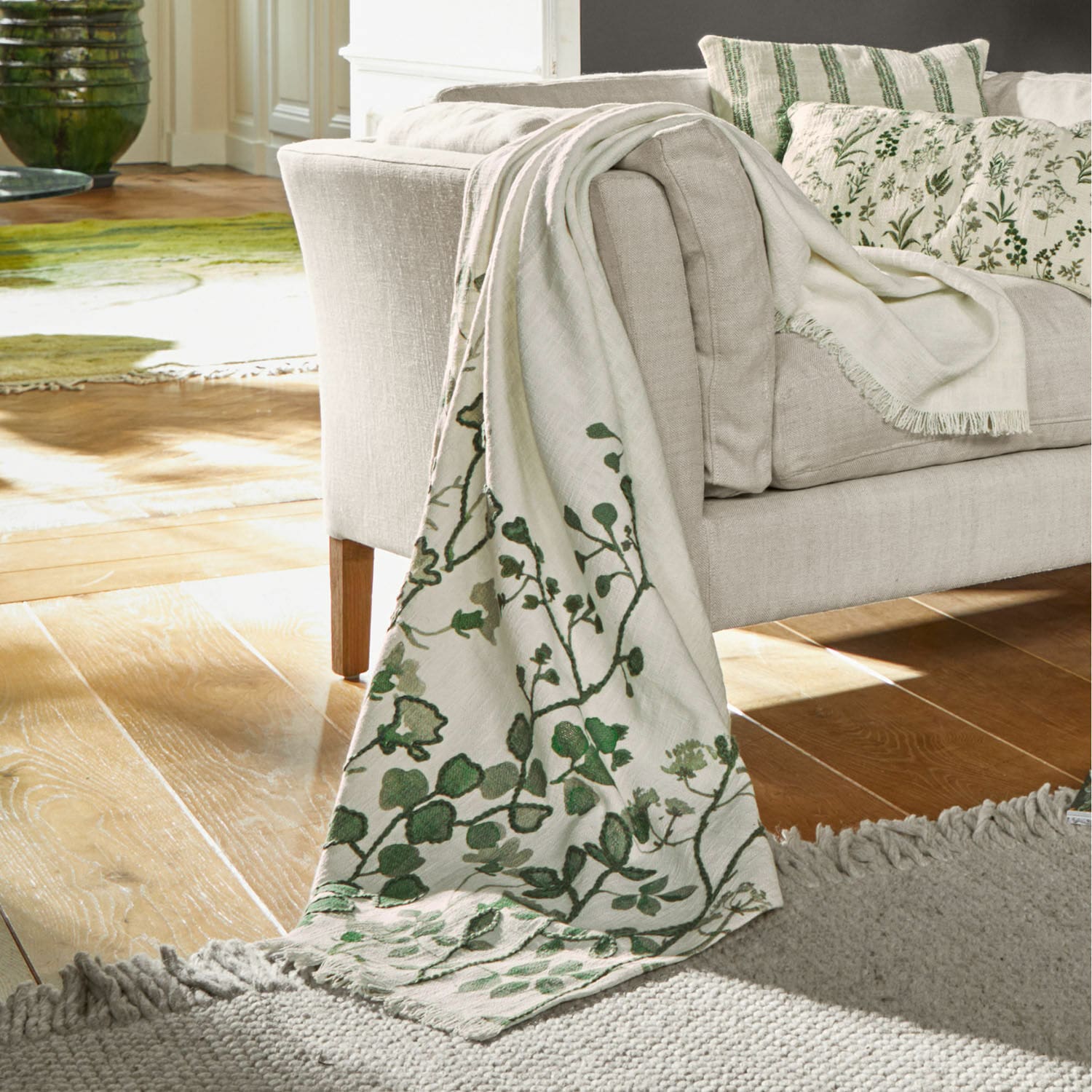 Plaid Wescombe Plaid beige avec motif végétal vert sur canapé, tissu doux, décoration intérieure cosy