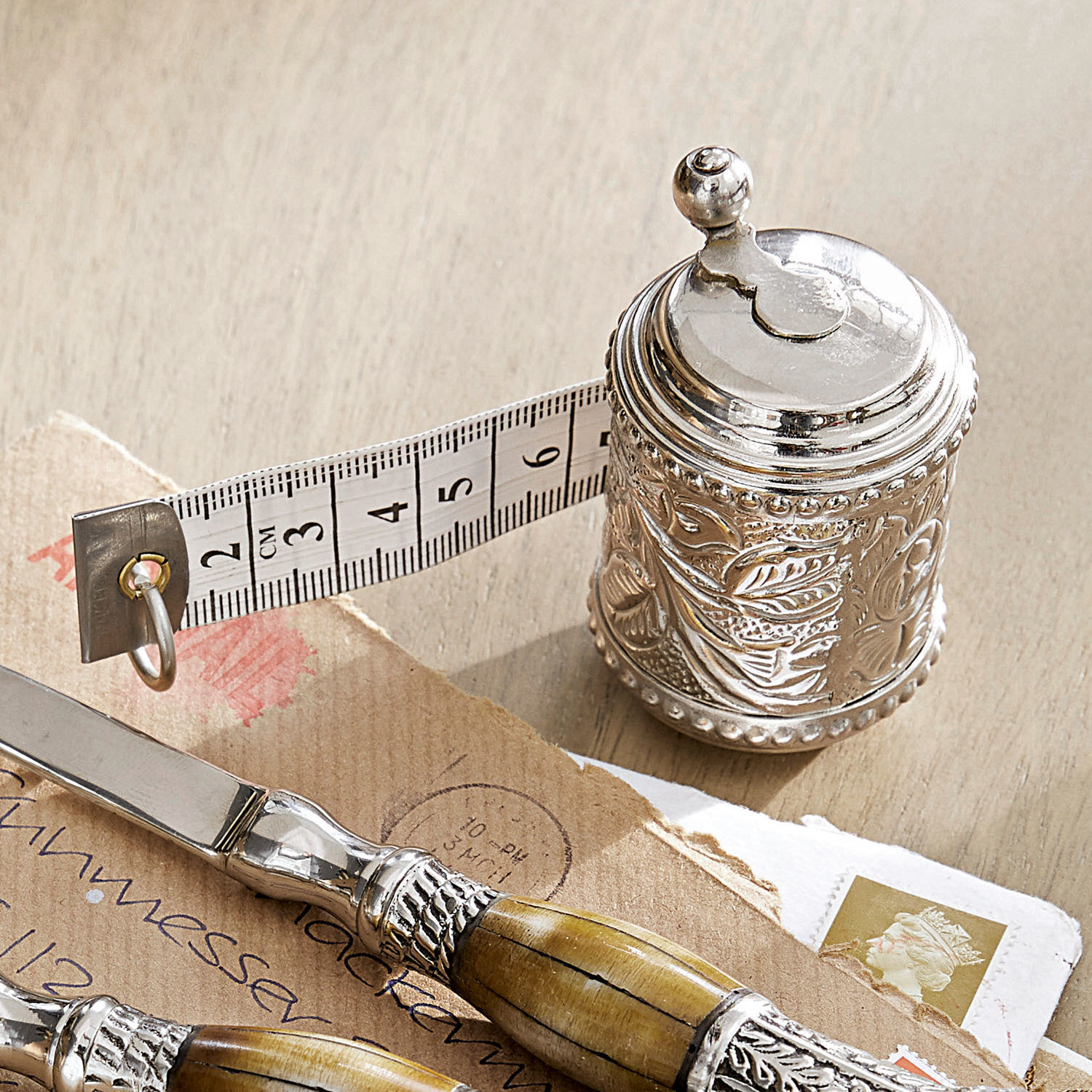 Mètre ruban Mètre Mètre ruban en métal argenté avec motif décoratif et bande de mesure blanche sur table en bois