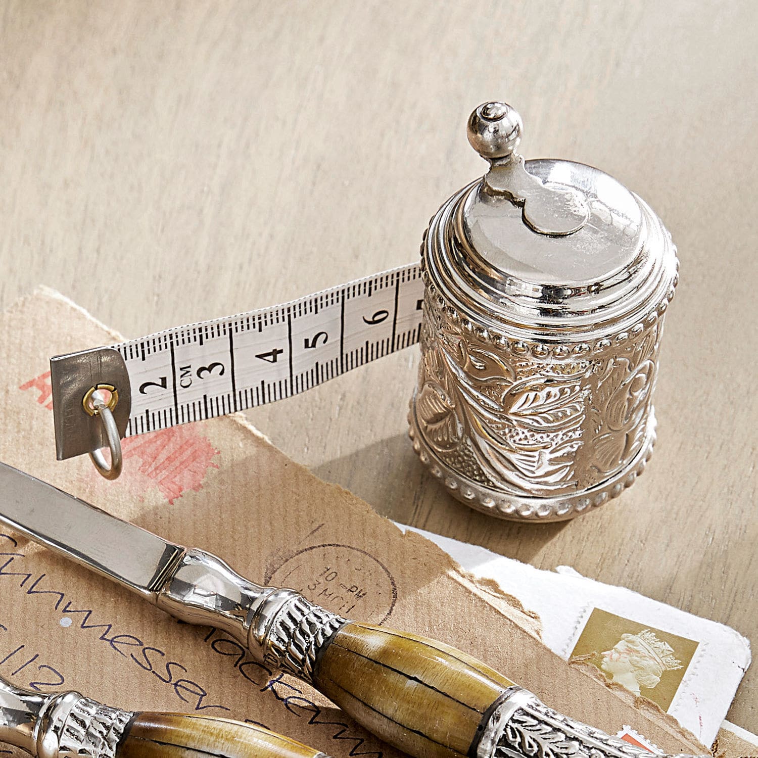 Mètre ruban Mètre Mètre ruban en métal argenté avec motif décoratif et bande de mesure blanche sur table en bois